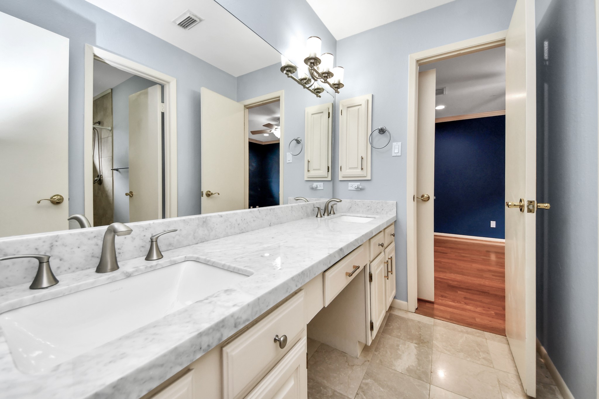 Updated secondary bath offers a long vanity with dual sinks and excellent counter and storage space.