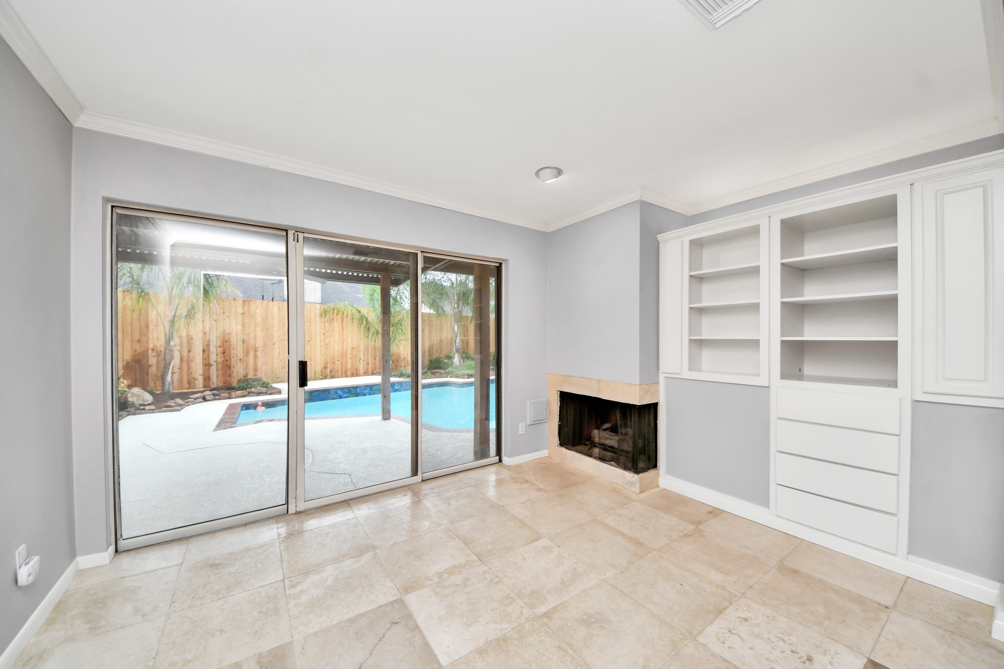 A special extension of the primary suite featuring built-in cabinetry, fireplace and sliding glass doors overlooking the poolideal for a private sitting room or retreat.