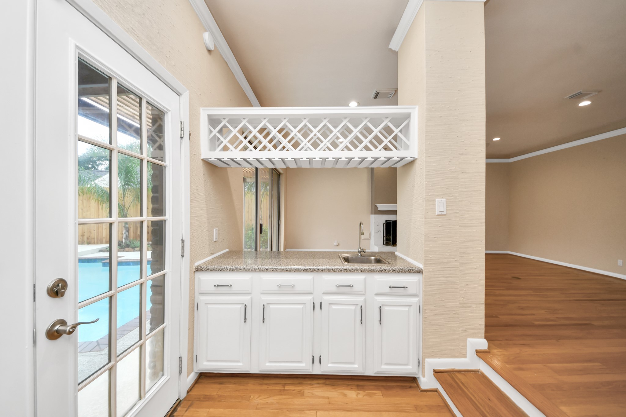 Convenient pass-through wet bar with wine storage overlooks the pool and connects the main entertaining spaces.