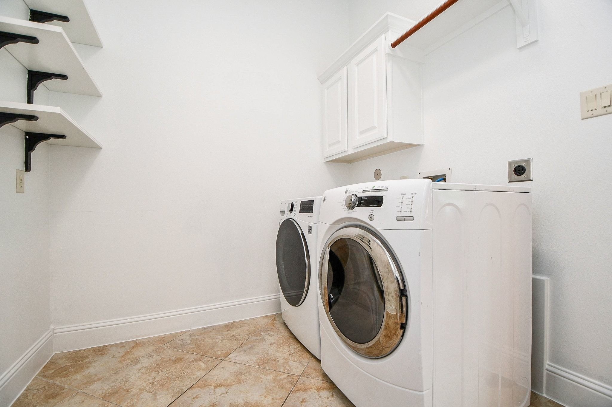 Utility room with Washer/Dryer with shelving and backpack rack.