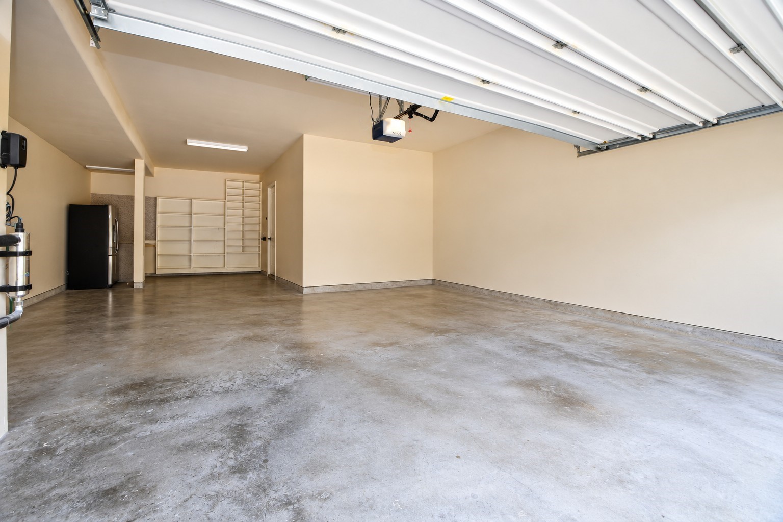 3 car garage with 5 ft extension, garage door opener, shelving, 2nd fridge for convivence...