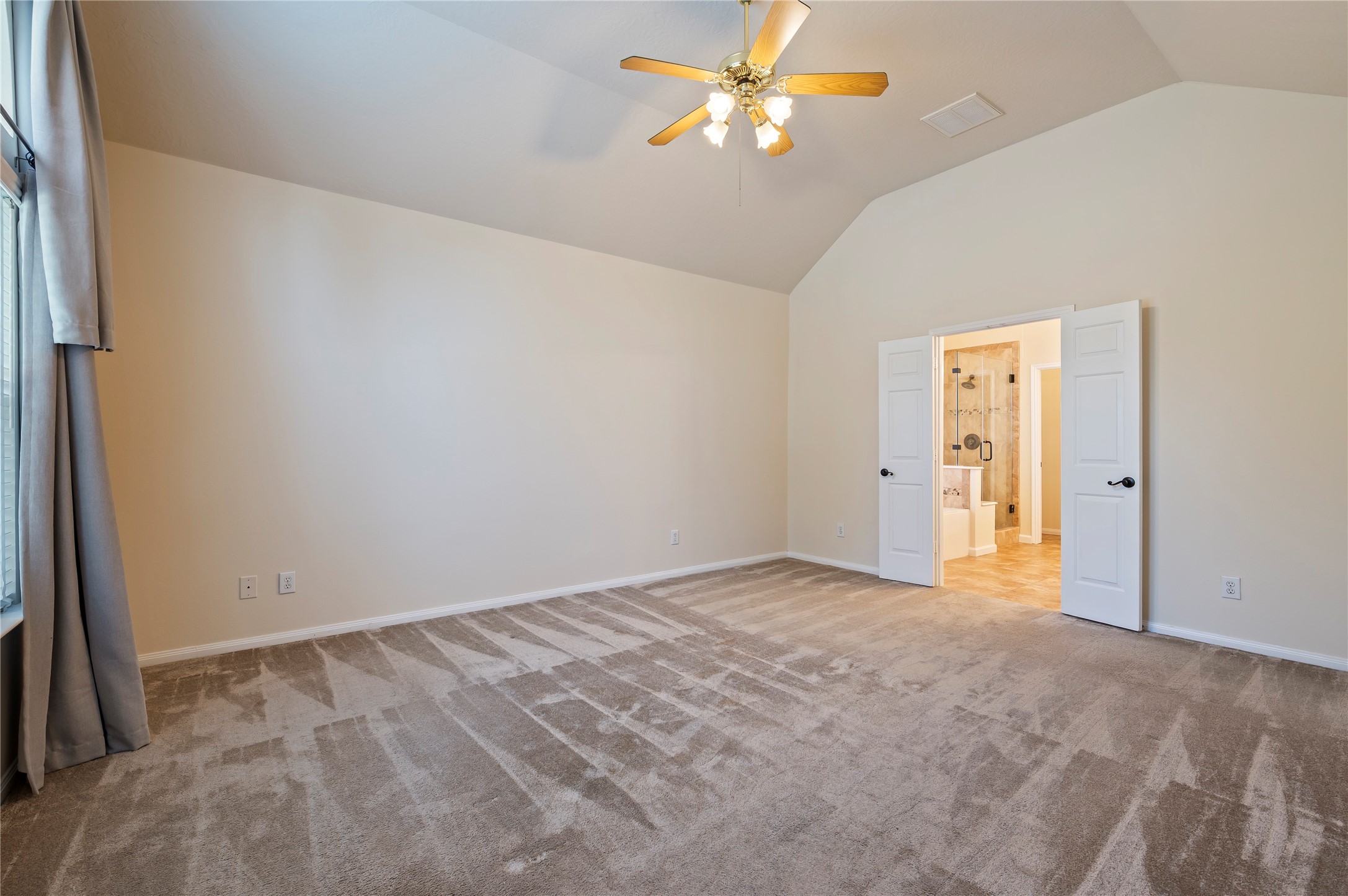 Primary bedroom with high ceilings and ensuite bathroom