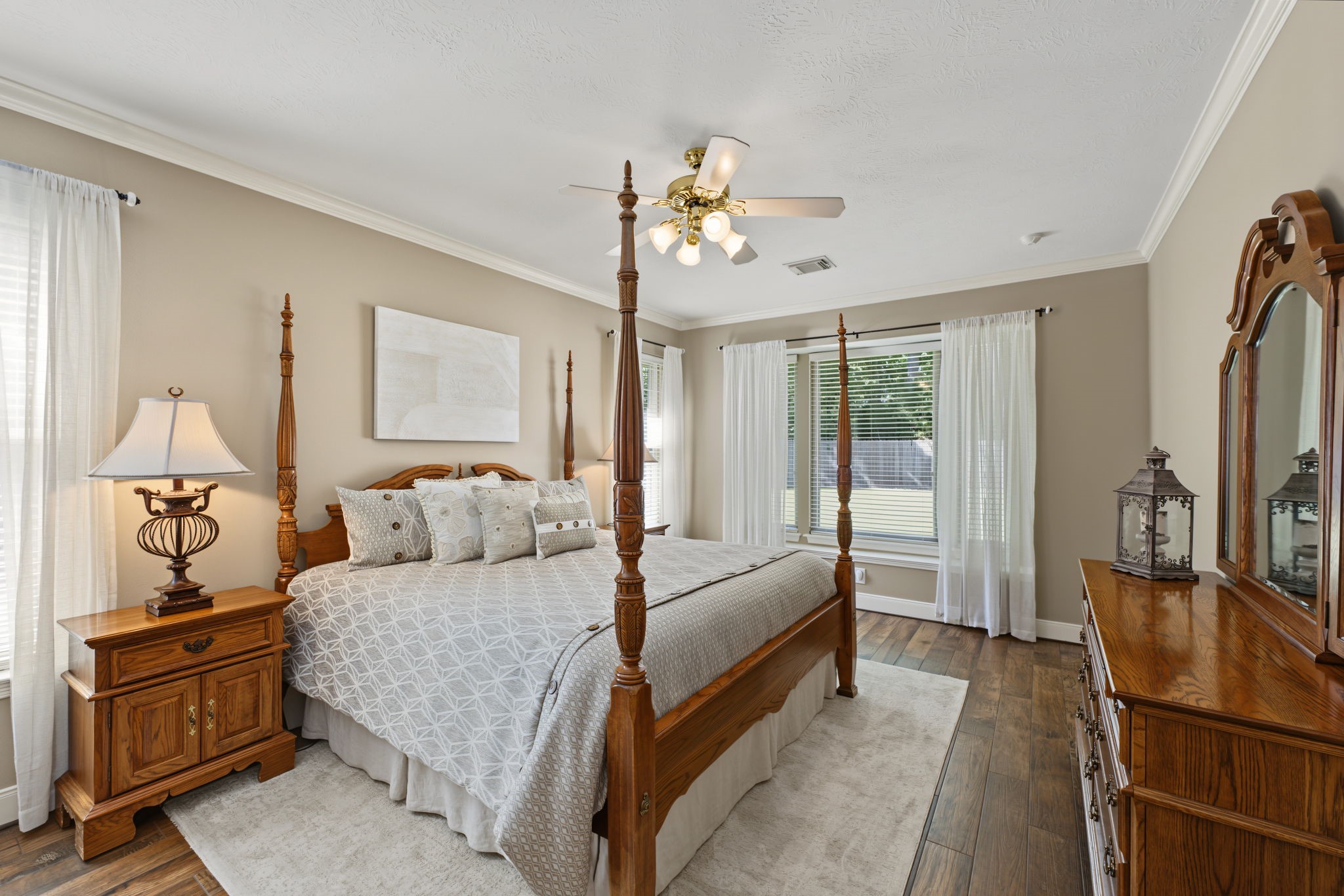 The Primary Bedroom measures approx 18' x 12' and contains wood-look tile flooring. Views to the backyard