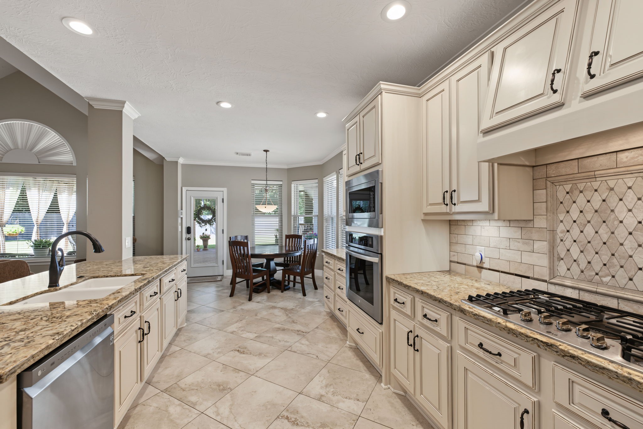 5-burner gas range with vent hood tucked underneath the top cabinets.