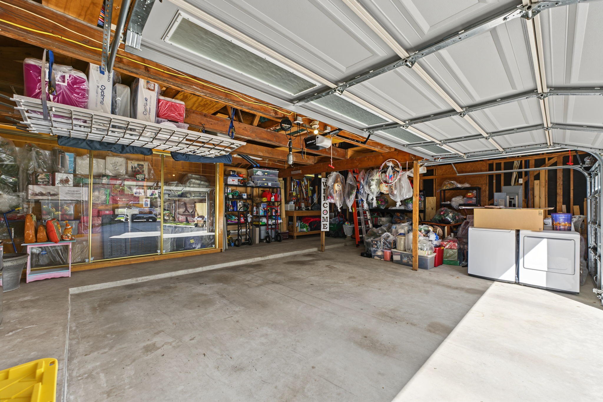This photo doesn't give this oversized 3-car-garage justice. Note the sliding glass walls for contained storage.