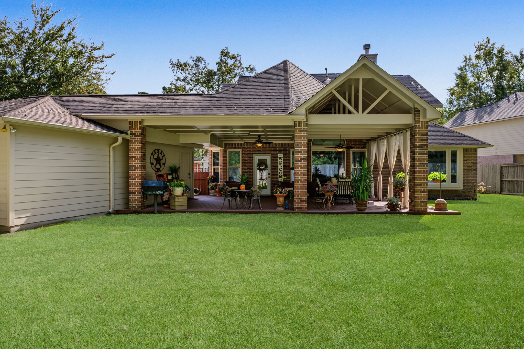 View from near the middle of the backyard grass space looking back onto the patio.
