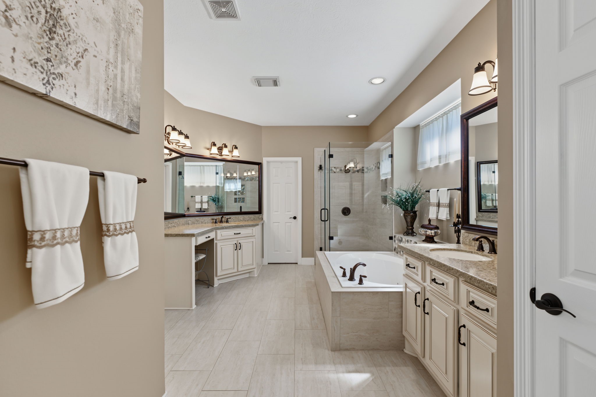 The Primary Bathroom is also updated with 2 completely separated vanity areas, a frameless shower, and jetted tub.