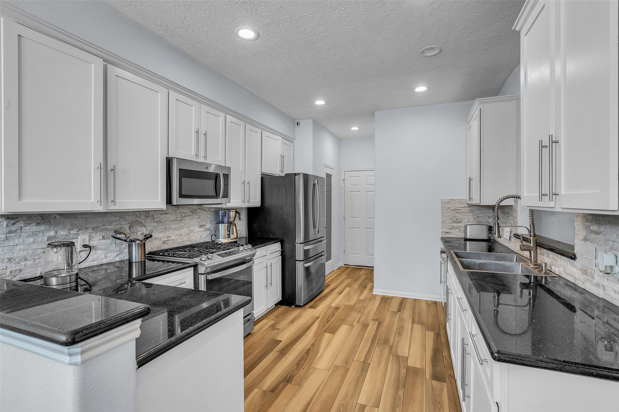 Stunning updated kitchen shines with a new backsplash and refinished cabinets.