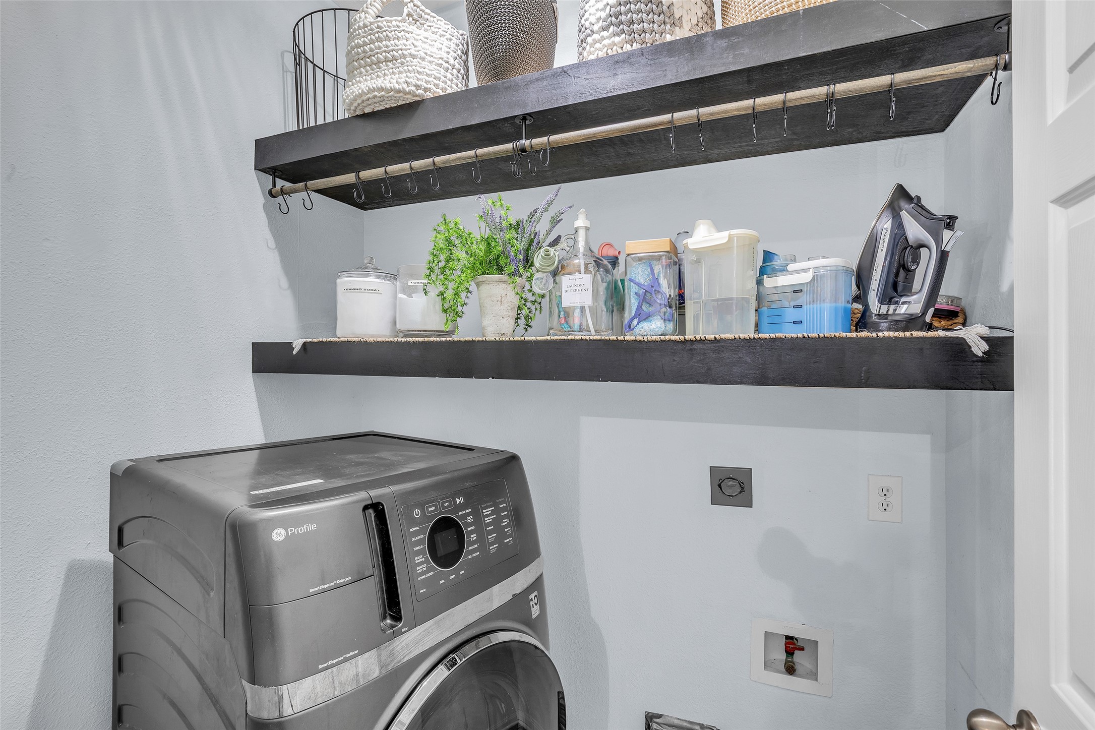 Conveniently located utility room with added shelving and storage.