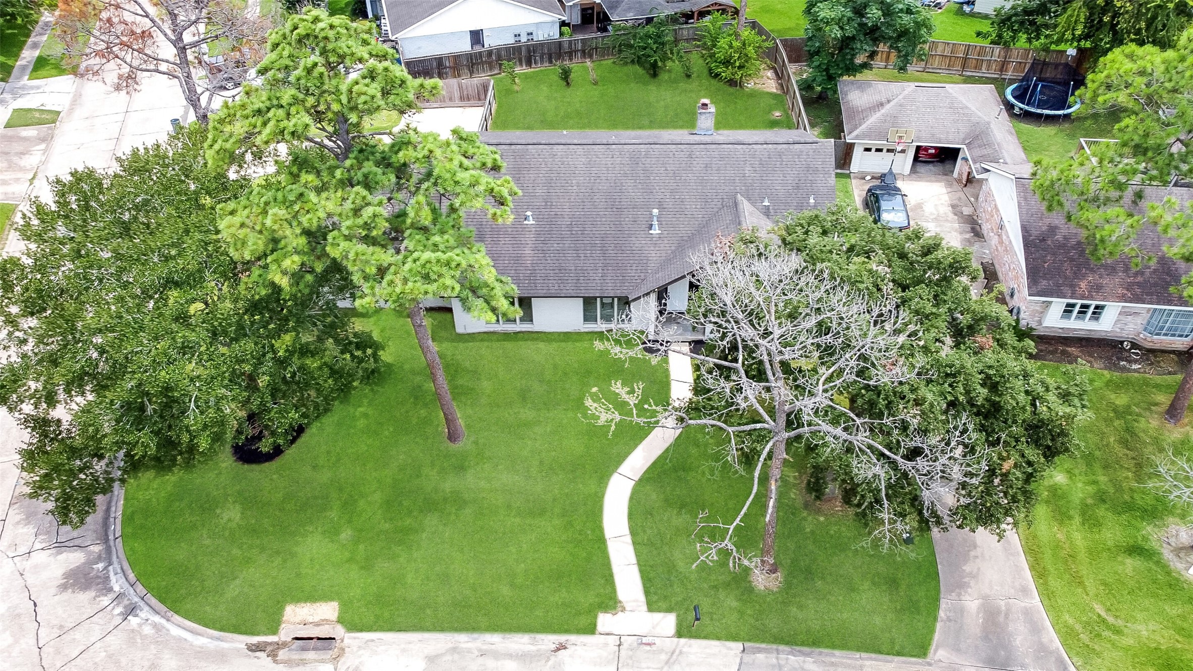 Aerial views showcase this spacious 2-story home on a large corner lot with mature trees, fenced backyard, and prime Wedgewood Village location in CCISD.