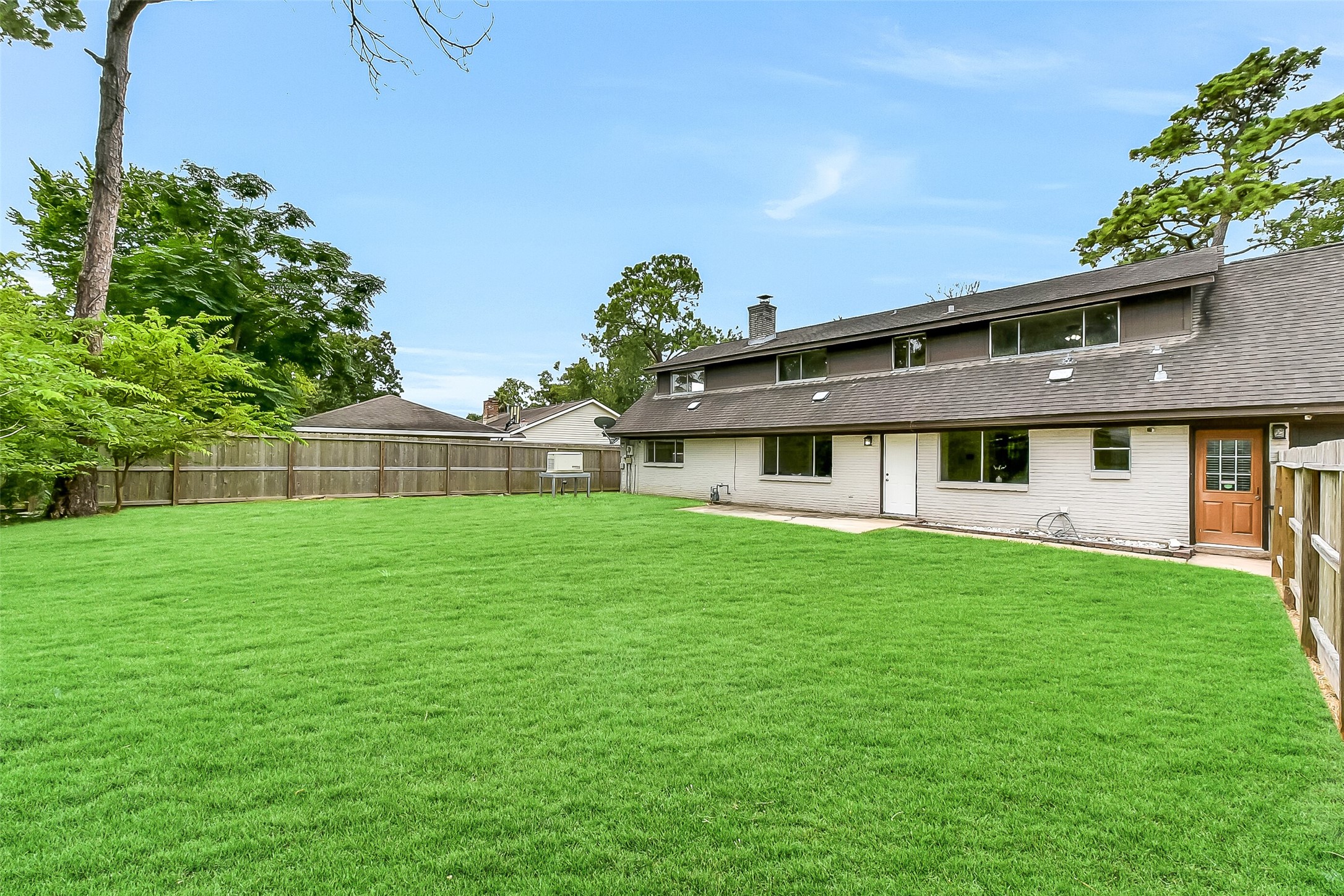 Expansive fenced backyard with a concrete patio area, mature trees, and plenty of open green spaceperfect for outdoor living, gardening, or entertaining. Also includes a whole-house Generac generator for peace of mind.