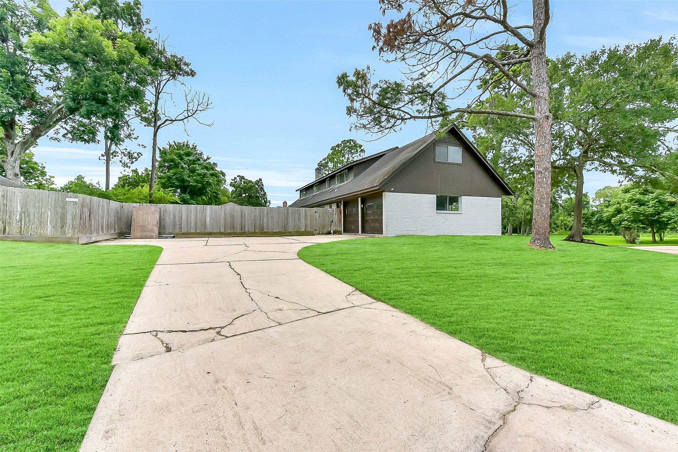 The extended driveway with ample parking space leads to the attached garage and fenced backyard. It is accessed from the side of this home on a corner lot.