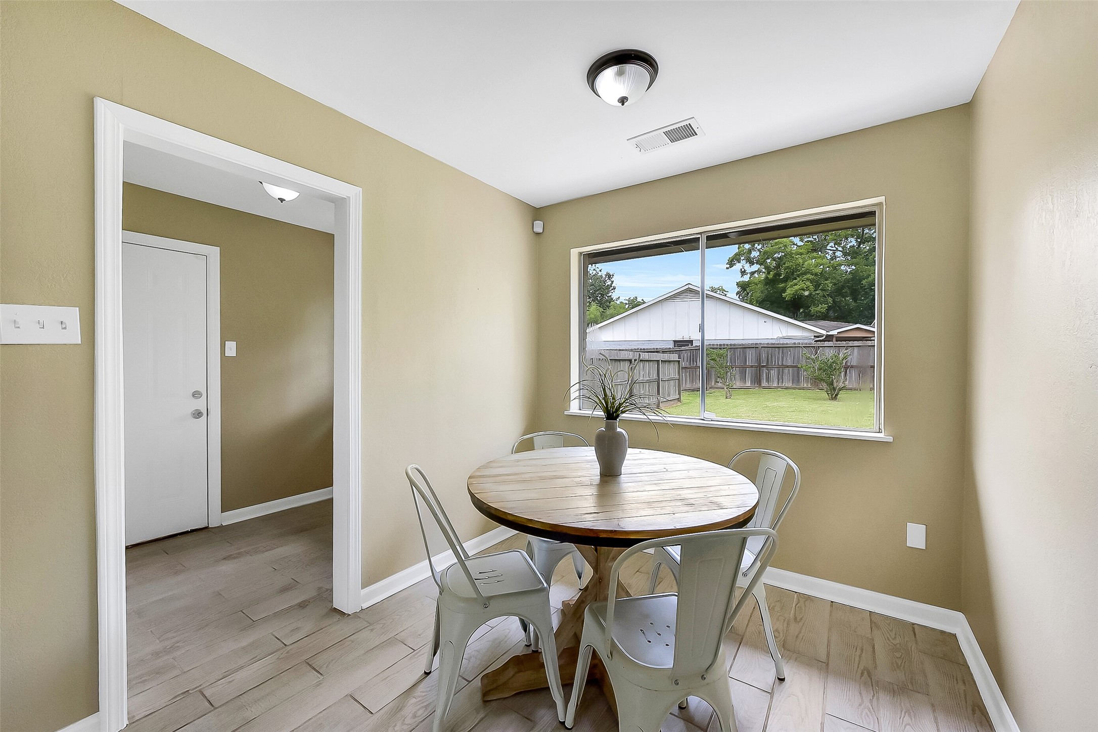 This light & bright breakfast nook with wood-look tile floors and large windows overlooking the backyard is situated between the family room, the indoor utility room, and the kitchen.