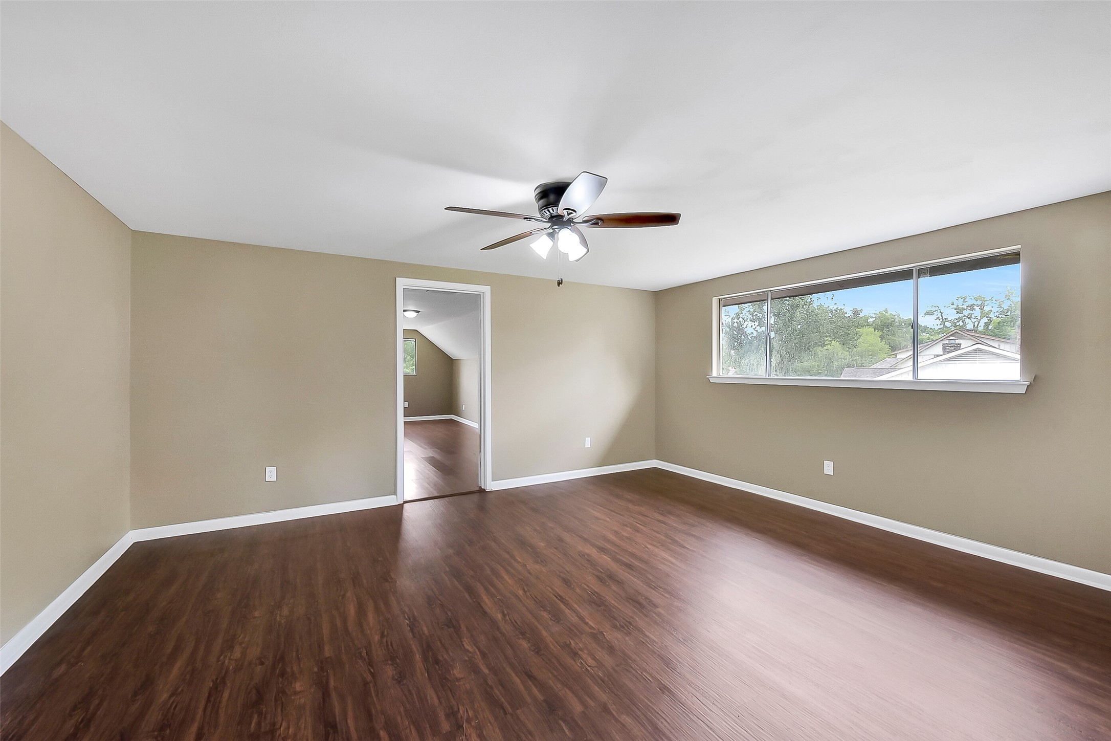 Spacious fourth bedroom upstairs with wood-look flooring, ample natural light, and an attached bonus room that offers endless possibilities for a study, playroom, or private retreat.