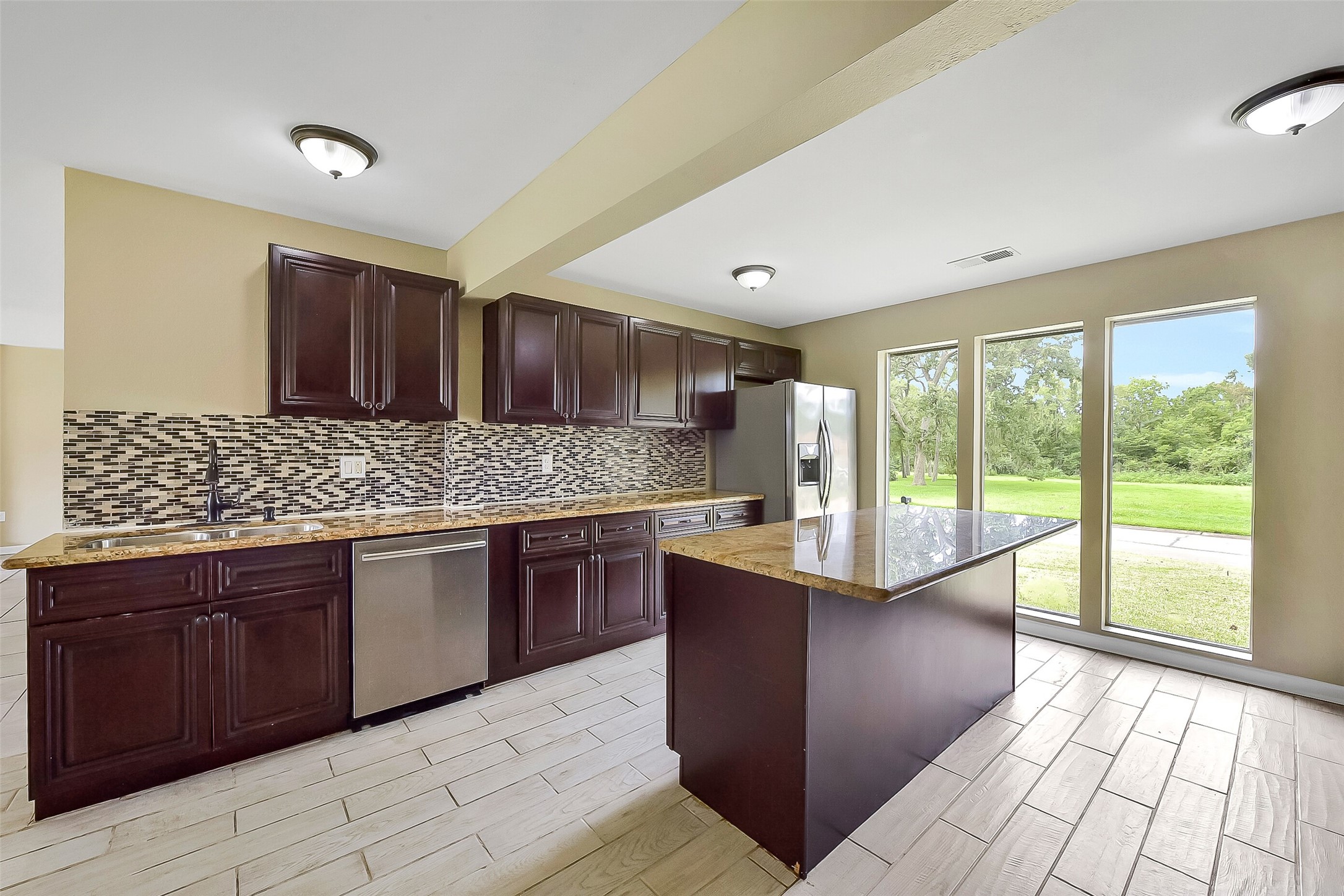 From the kitchen, enjoy floor-to-ceiling windows that fill the space with natural light and showcase serene outdoor views.