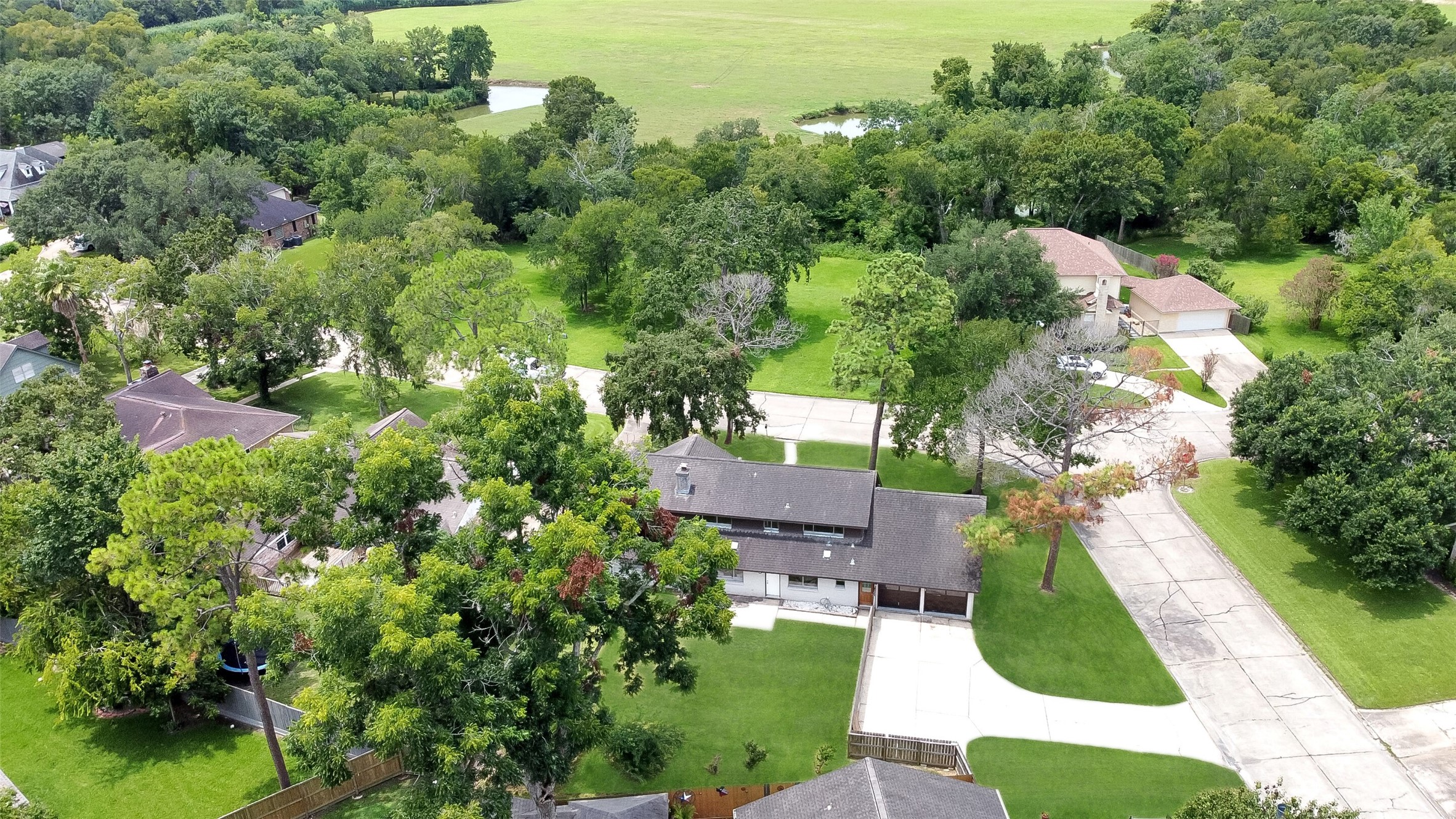 Aerial views showcase this spacious 2-story home on a large corner lot with mature trees, fenced backyard, and prime Wedgewood Village location in CCISD.