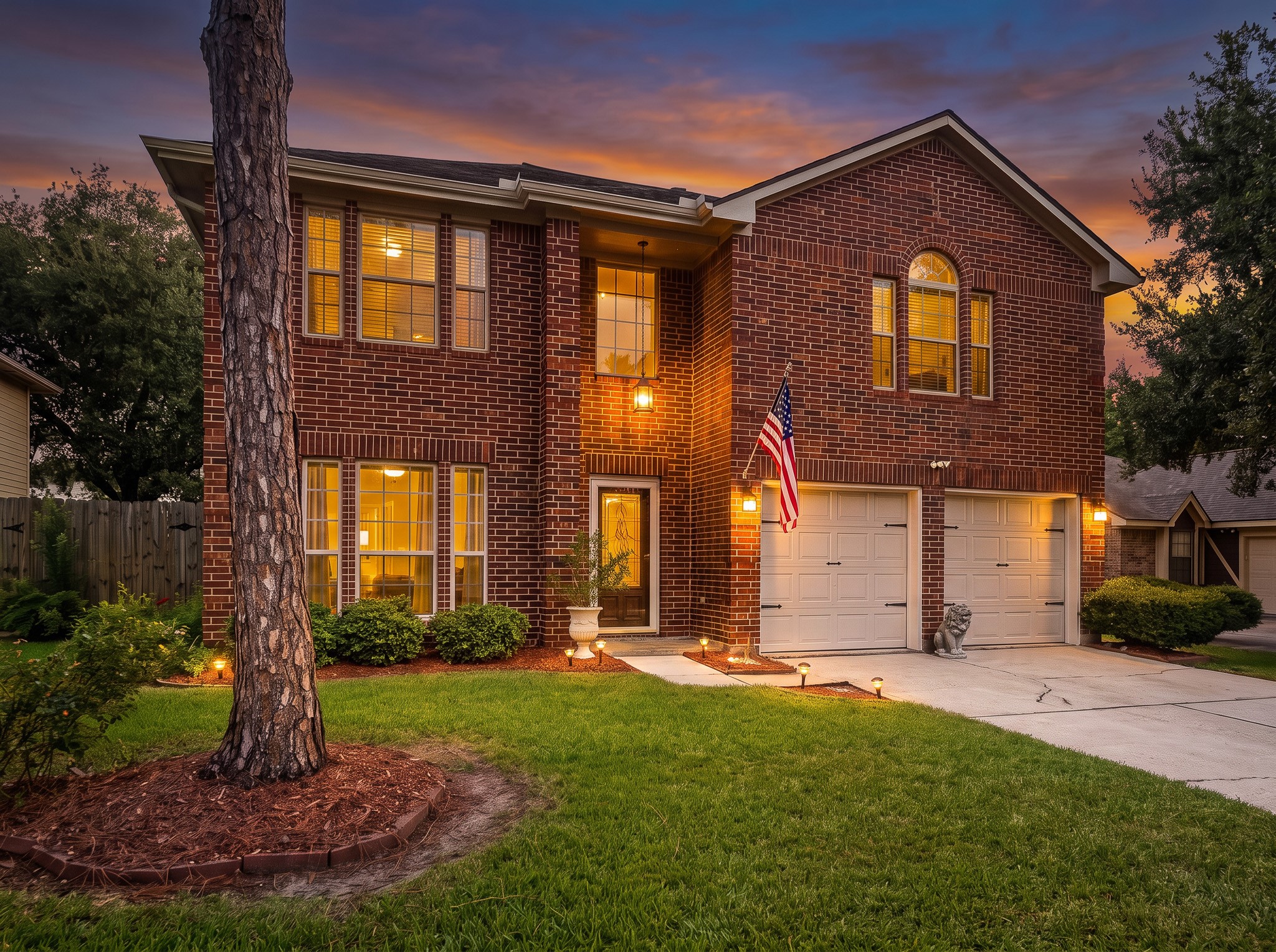 Welcome to 1118 Wentworth Drive, a two-story brick-and-siding residence showcasing refined curb appeal, a wide driveway leading to a two-car garage, manicured landscaping, and accent illumination.