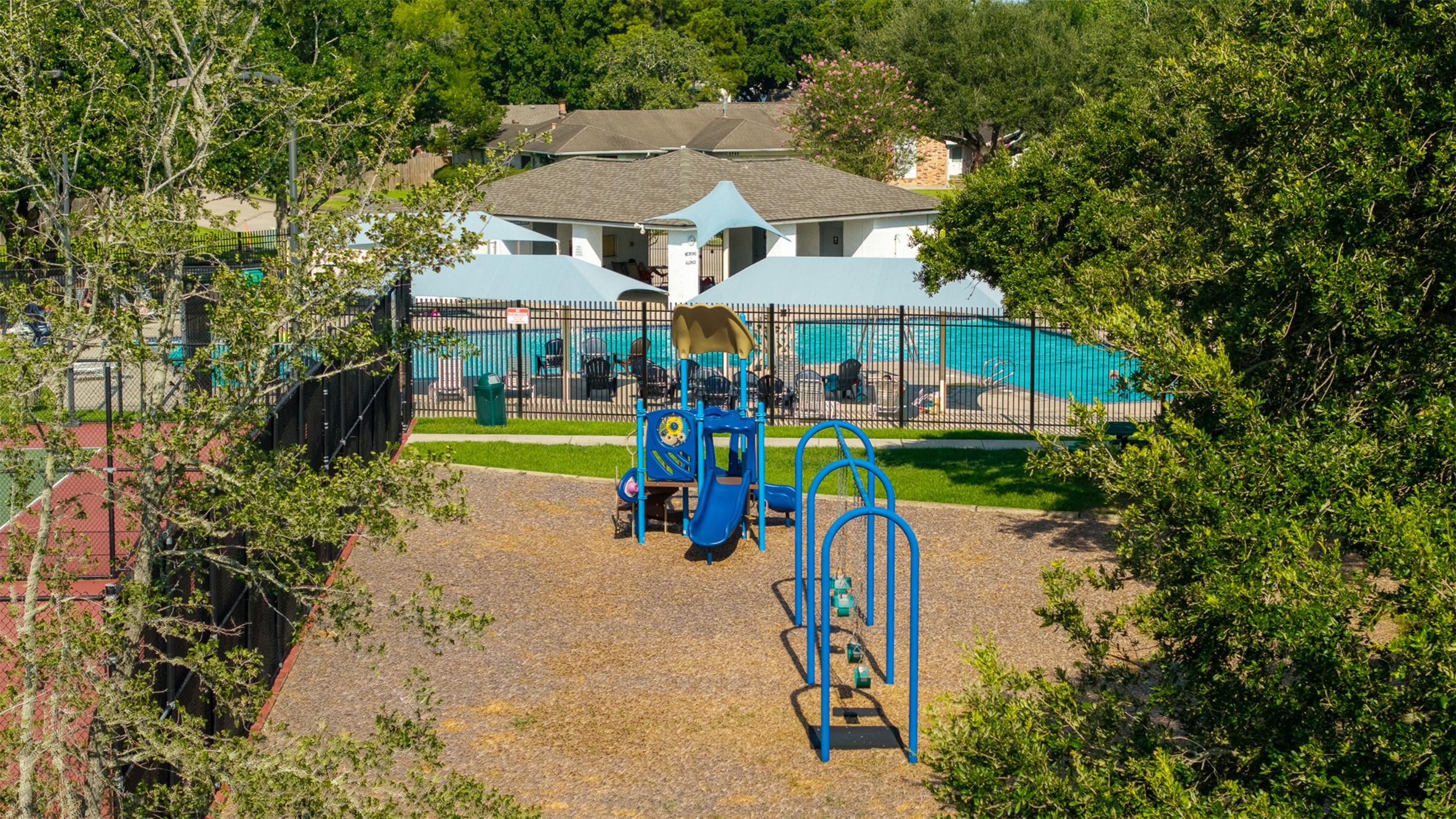 Perched beside the tennis courts, this vibrant play area features a colorful jungle gym, swing set, and a soft mulch surface. Beyond the perimeter fence, residents enjoy access to a shaded community pool and pavilion.