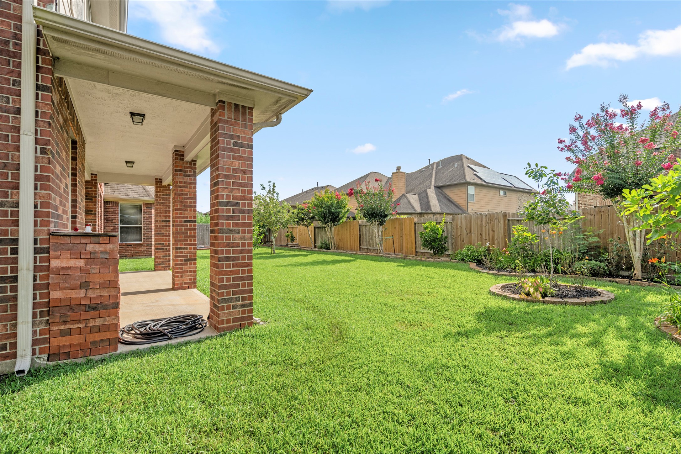 The professionally manicured backyard unfolds with a lush green lawn and mature, fruit-bearing trees a private outdoor oasis ready to enjoy.