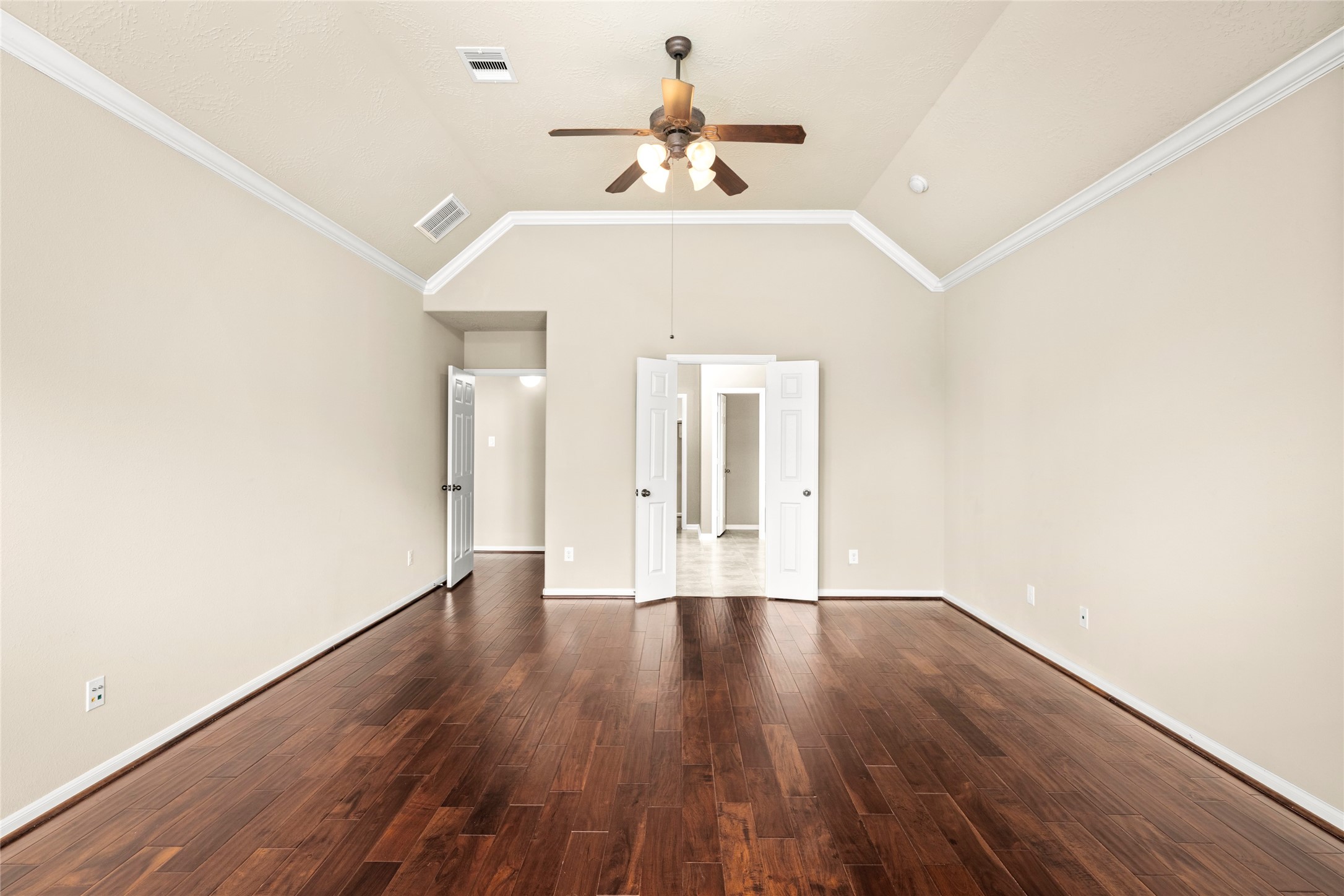 The primary suite's wood flooring and double doors lead gracefully into the spa-inspired ensuite bath, true luxury, thoughtfully connected.