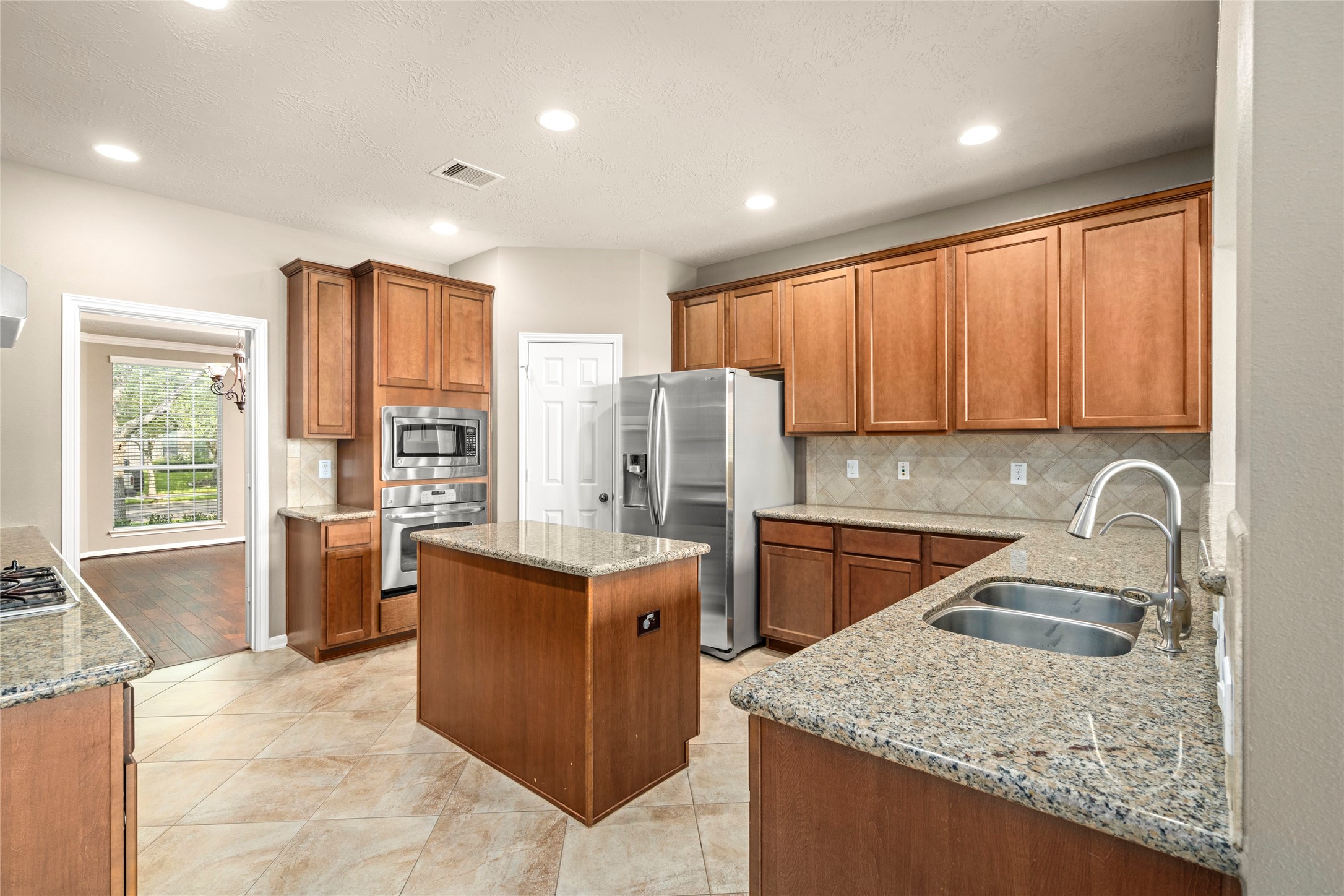 The chef's kitchen impresseswith granite countertops, a generous island wired for convenience, gas cooktop, built-in microwave, and a refrigerator that stays, culinary luxury at its finest.