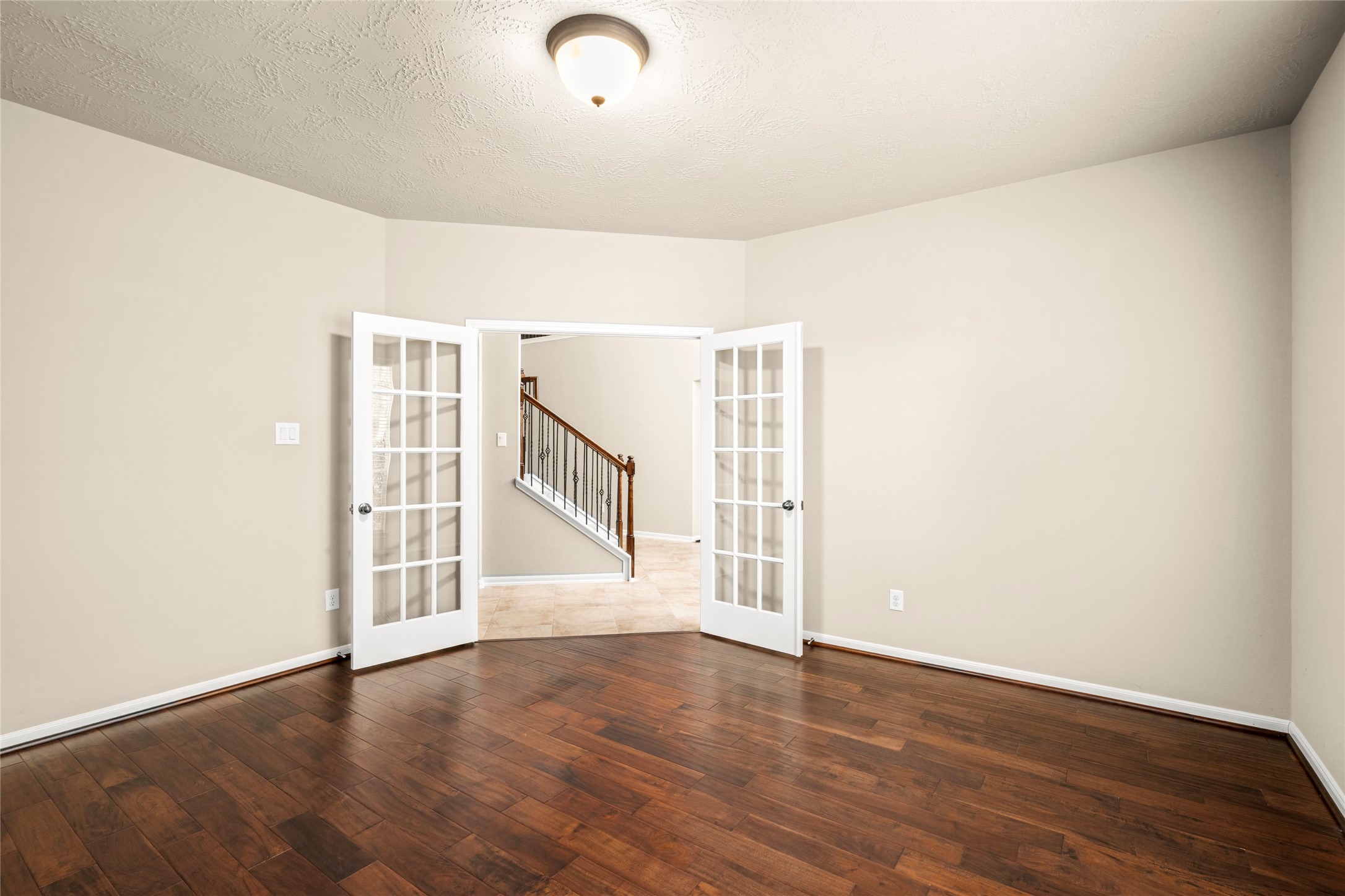 Generous in scale and bright throughout, this homeoffice boasts gleaming wood floors, French doors, and a view to the staircase beyon. A versatile space ready for your vision.
