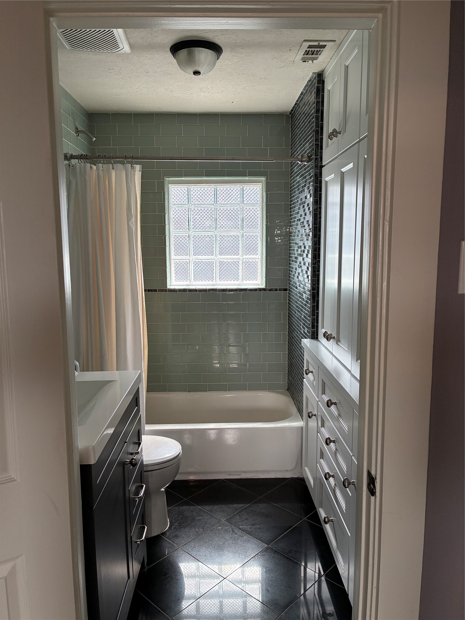 Nicely re-done bathroom with ample storage space.