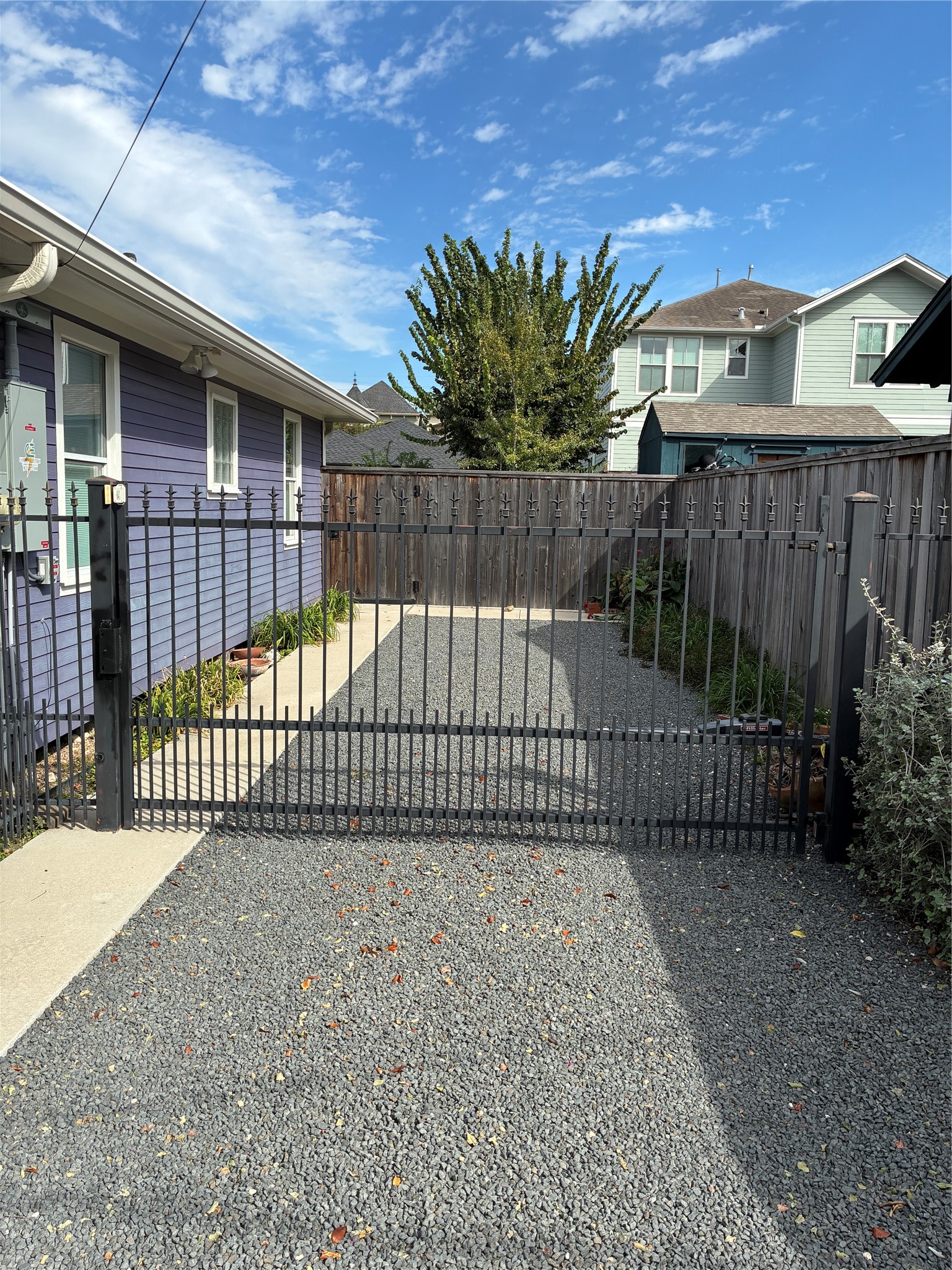 Recently installed black star-lined drive with remote control entry gate.