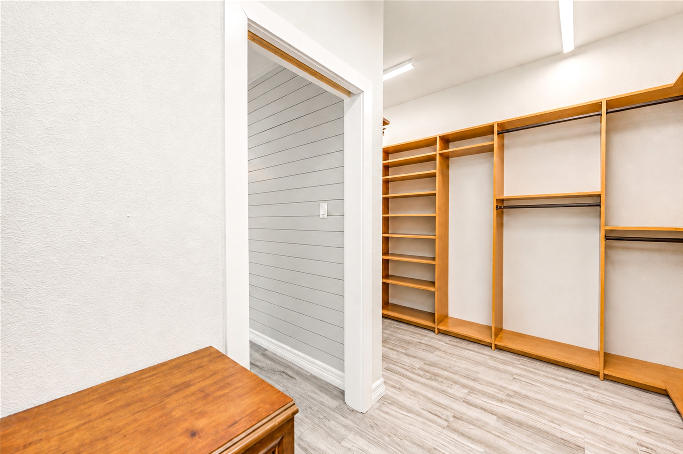 Custom built-in shelving and generous hanging space provide thoughtful organization in the spacious primary closet.