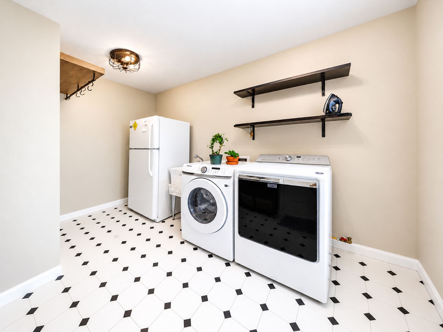 Spacious laundry room with patterned tile flooring and open wall shelving.