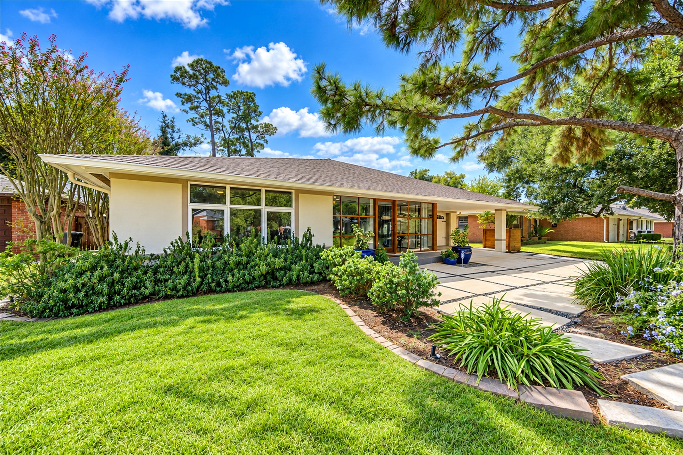 Clean mid-century lines, expansive wood-framed windows and mature landscaping give this single-story home its distinctive architectural character.