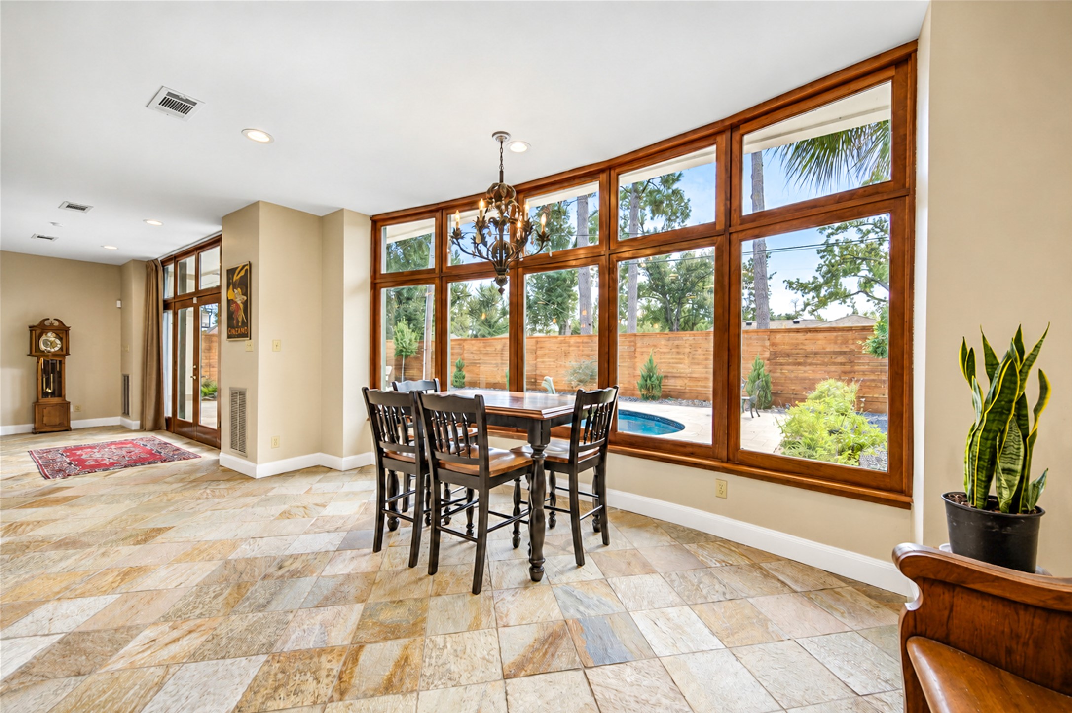 A bay of wood-framed windows fills the dining area with natural light and frames views of the yard.