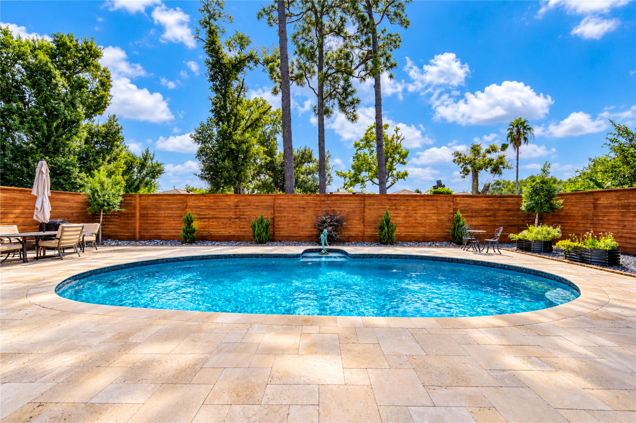 A beautiful gunite pool, expansive travertine decking and mature landscaping create an inviting backyard setting for outdoor living.