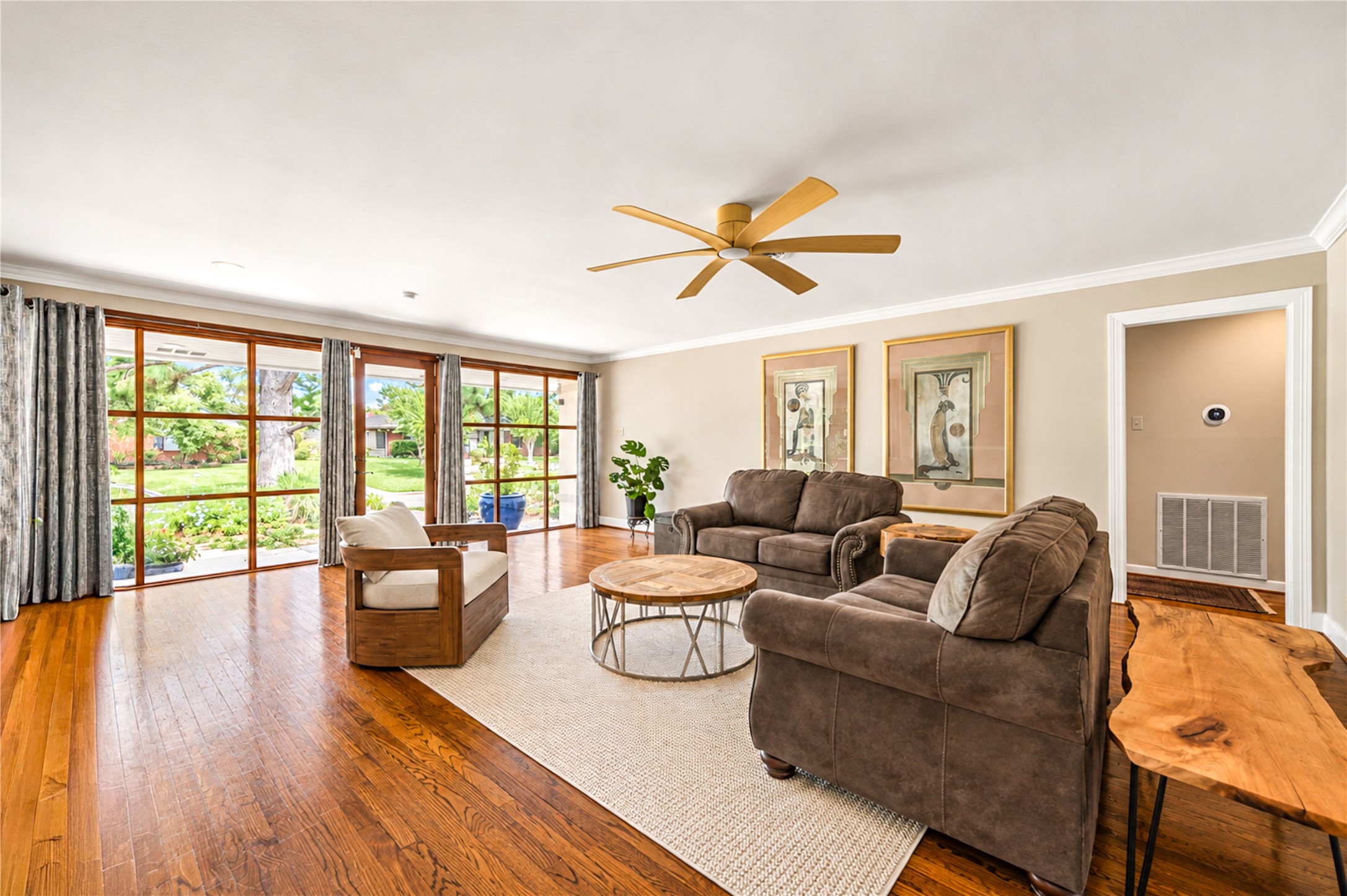 Hardwood flooring extends across the generous living room, where wood-framed glass opens the space to the garden. Hardwood flooring extends across the generous living room, where wood-framed glass opens the space to the garden.