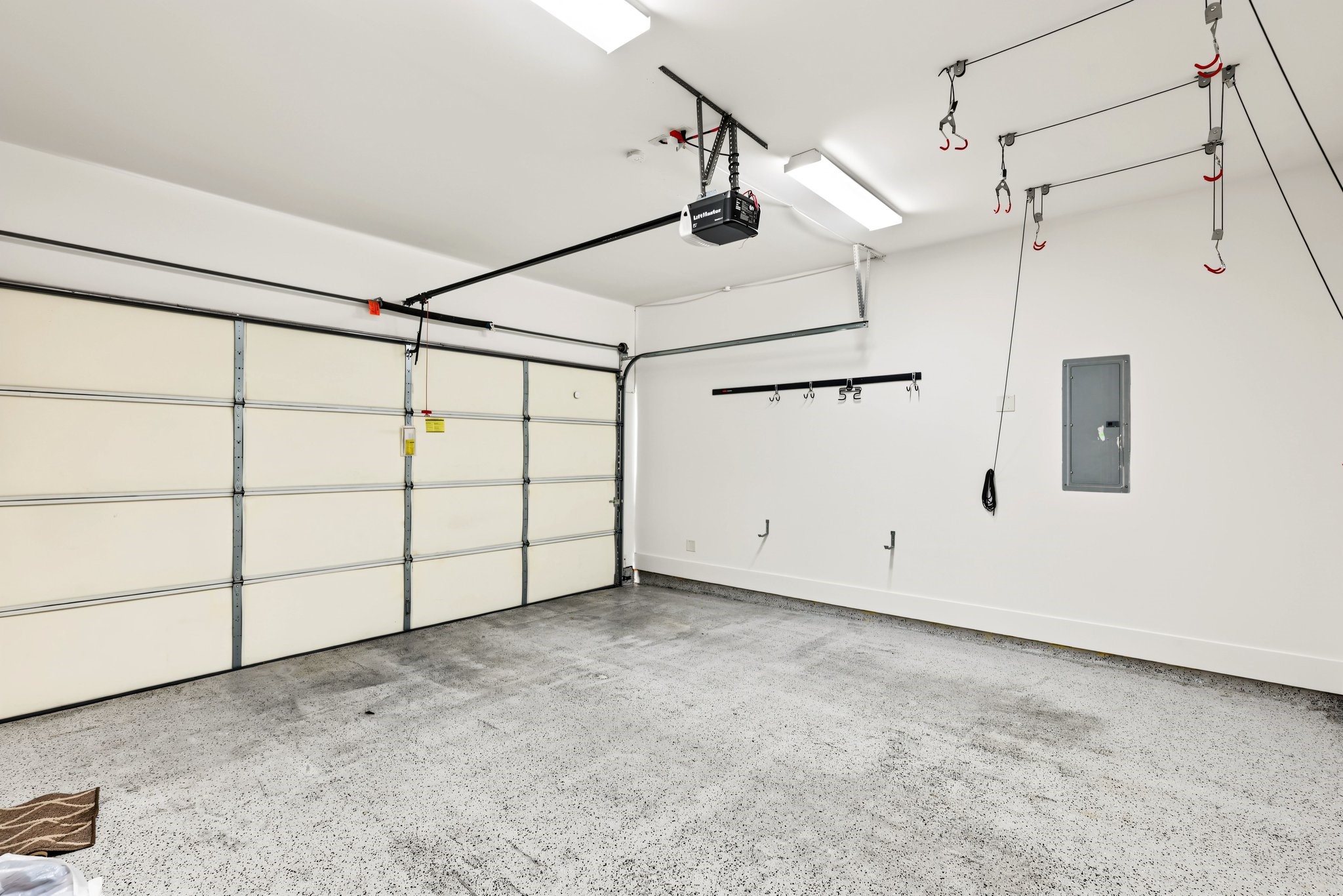 Enjoy the everyday convenience of a private, attached two-car garage equipped with an automatic door opener. Durable speckled epoxy flooring and a bright, well-lit interior create an impeccably clean, functional space for secure parking, extra storage, and weekend projects.