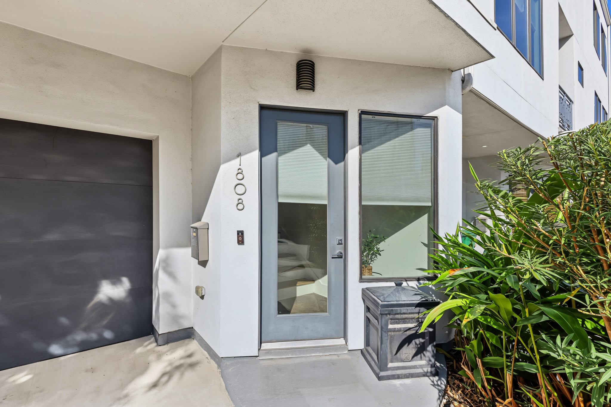The propertys curb appeal is completed by intentional exterior landscaping and perimeter details, including a rich, horizontal-slat wooden privacy fence enclosing the side yard, a rock-landscaped bed anchored by a mature shade tree, and established ornamental trees and green shrubbery framing the front entrance.