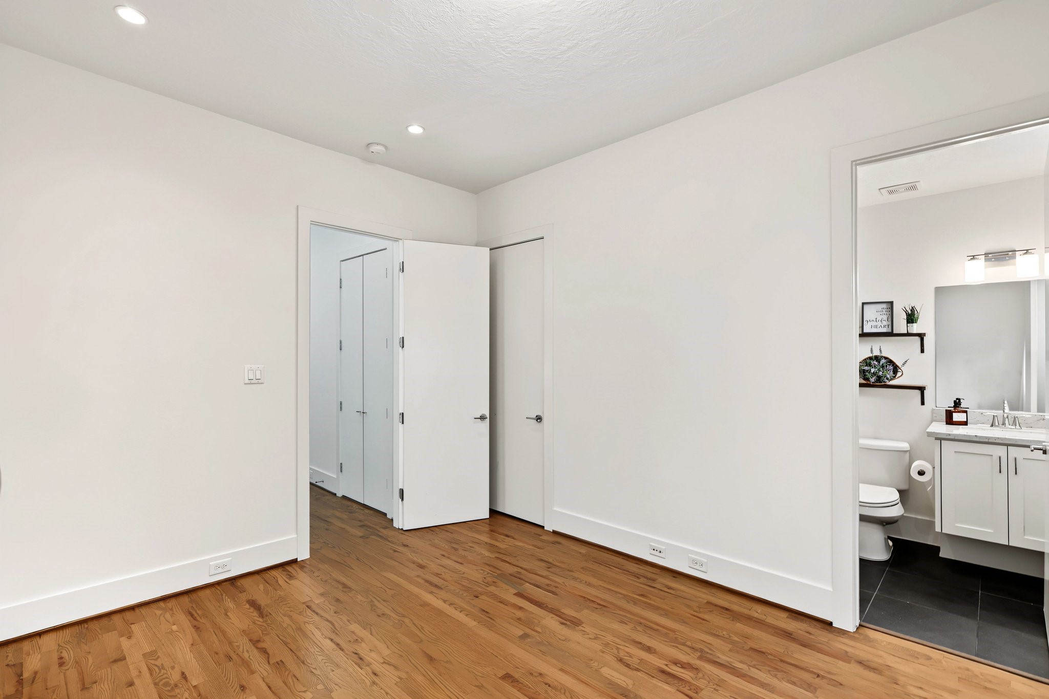 An adjoining en-suite bath and dedicated walk-in closet provide everyday ease and privacy for this secondary bedroom. The well-appointed layout establishes a secluded, comfortable retreat for visiting guests or a serene space to call your own.