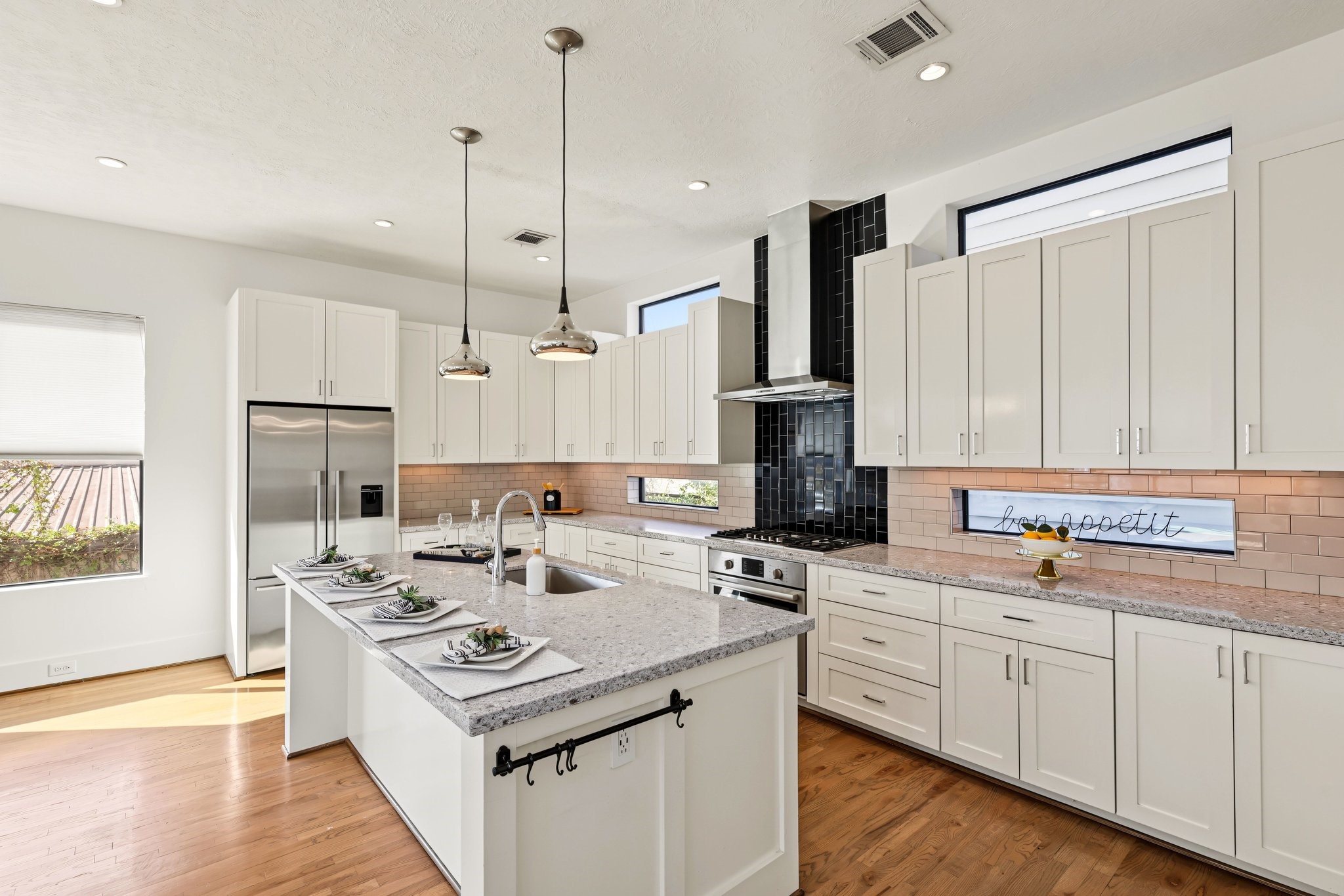 Premium Bosch stainless steel appliances, slab quartz countertops, and timeless Shaker-style cabinetry anchor this sleek contemporary kitchen. A classic subway tile backsplash, solid white oak floors, and dedicated pantry storage strike the ideal balance between elevated design and effortless daily utility.