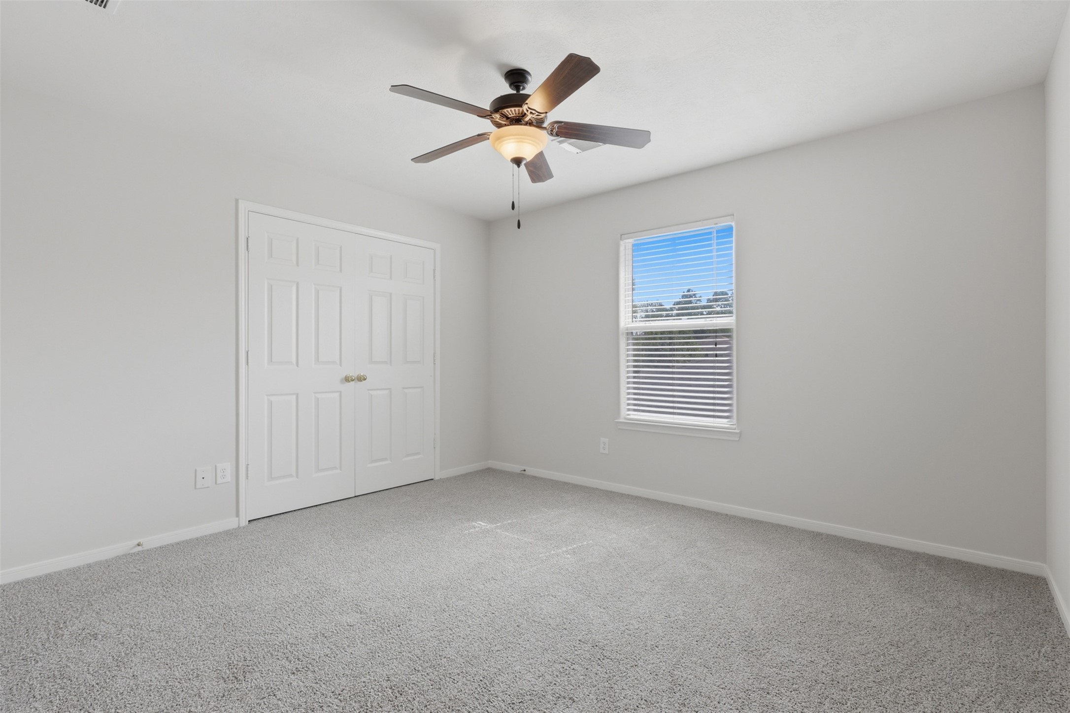 Spacious secondary bedroom featuring fresh neutral paint, brand new carper, bright natural light, and plenty of space for your furnishings.
