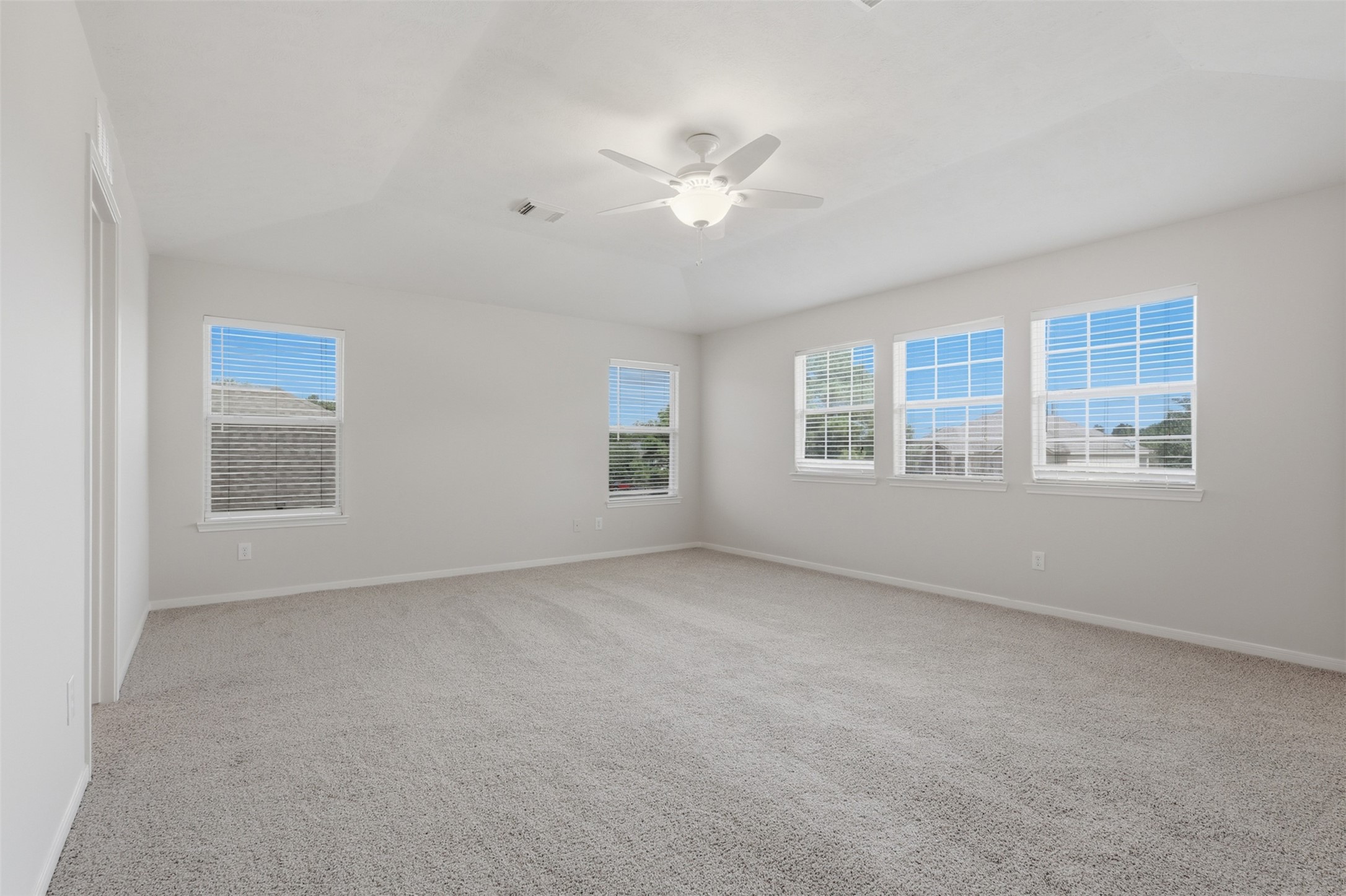 This massive primary bedroom on the second floor boasts five large windows that fill the space with natural light, brand-new carpet, and fresh paint throughout.