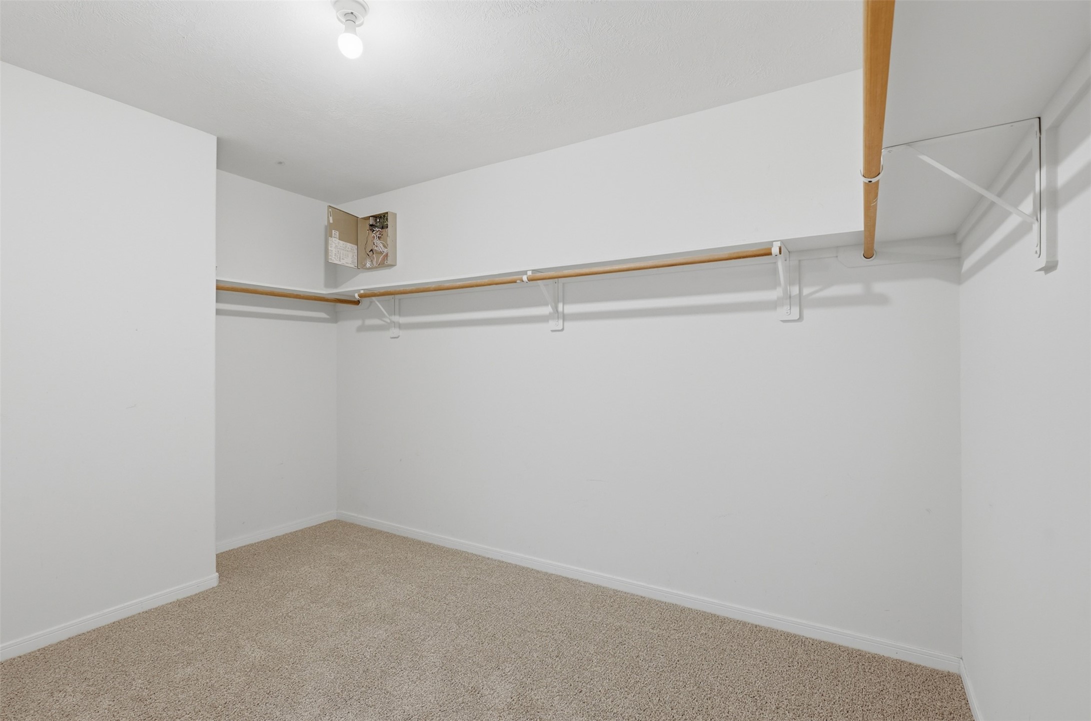 Generously sized primary walk-in closet! Features wrap-around clothes racks and top shelving with plenty of floor space for shoe racks, dressers, or custom closet organization.