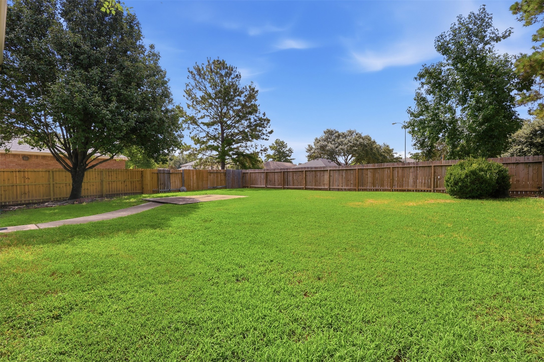 Spacious fully-fenced backyard with lush grass and beautiful shade treesyour own private outdoor oasis!