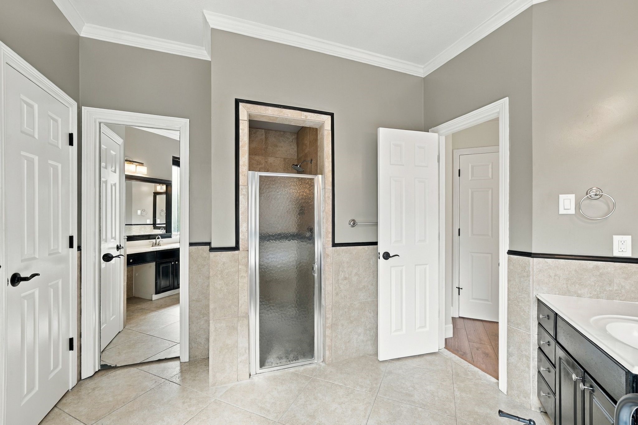 Stand alone shower with glass door, full length mirror on the walk in closet door.