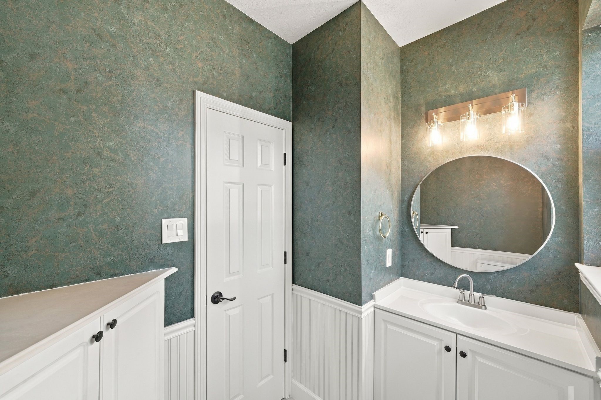 The half bath is located downstairs near the laundry room.