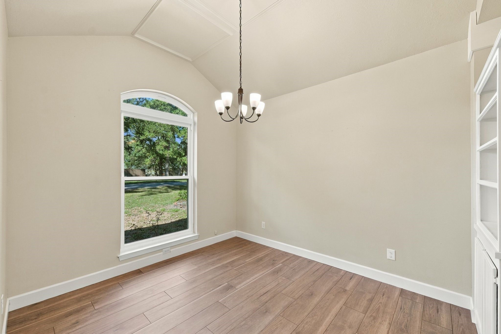 This home office with custom built ins has neutral paint, updated flooring, white trim and updated lighting.
