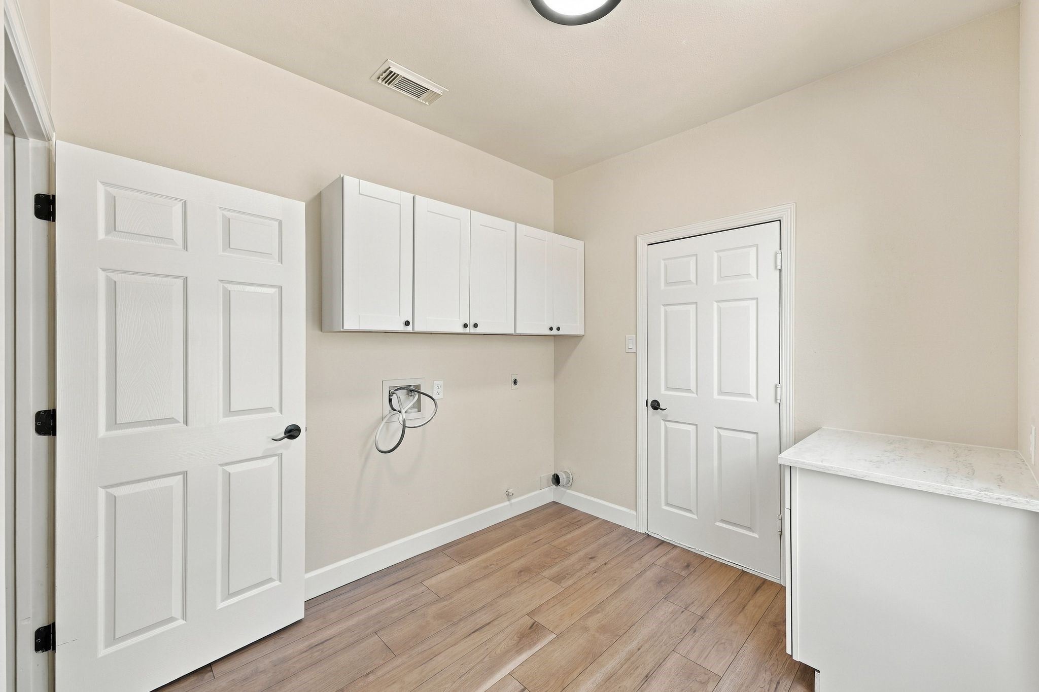 The laundry room is located just off of the entrance to the home from the garage. So roomy with storage and a folding counter!