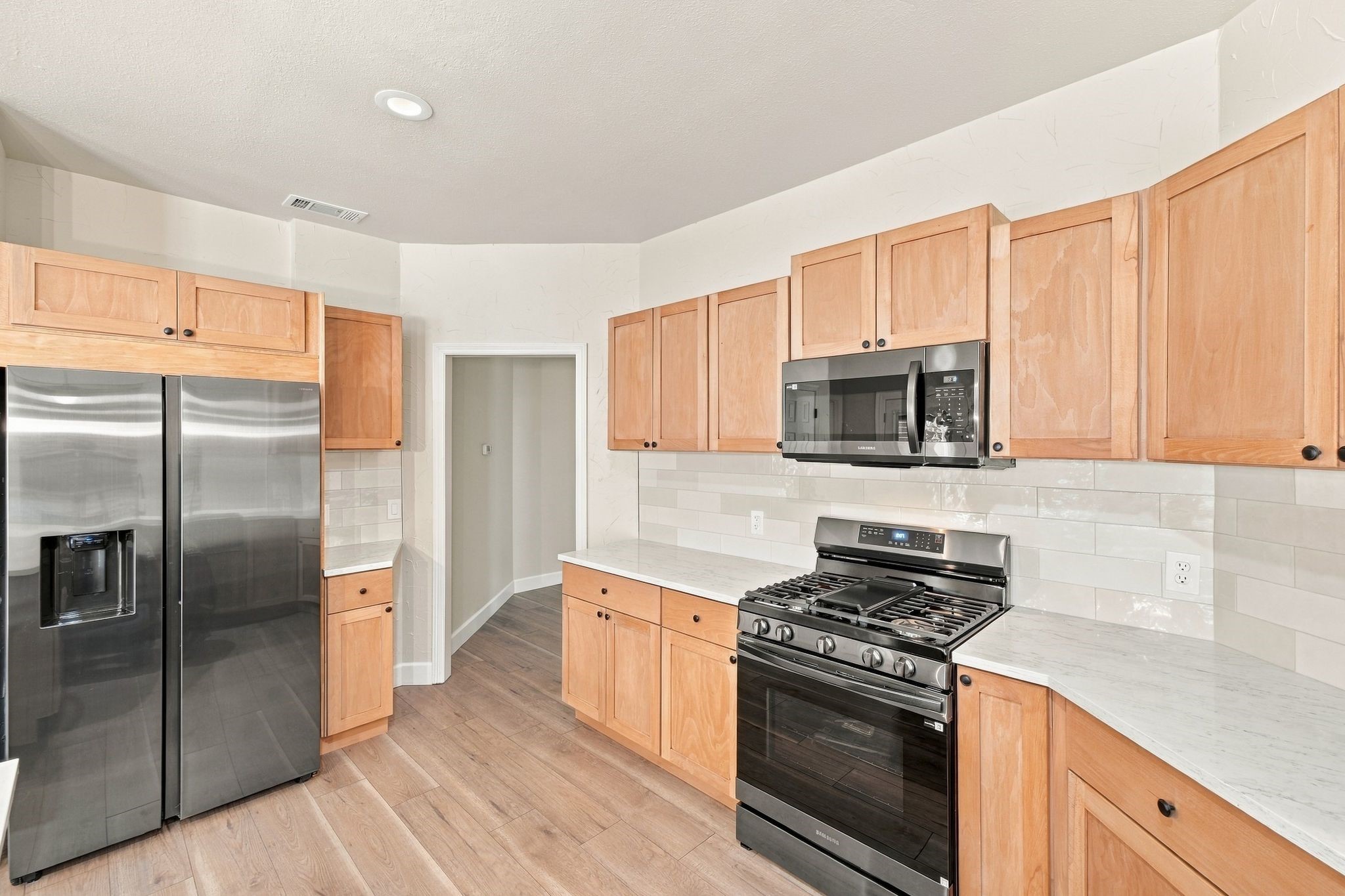 Stainless steel appliances were recently installed. Love the quartz countertops and the tile back splash!