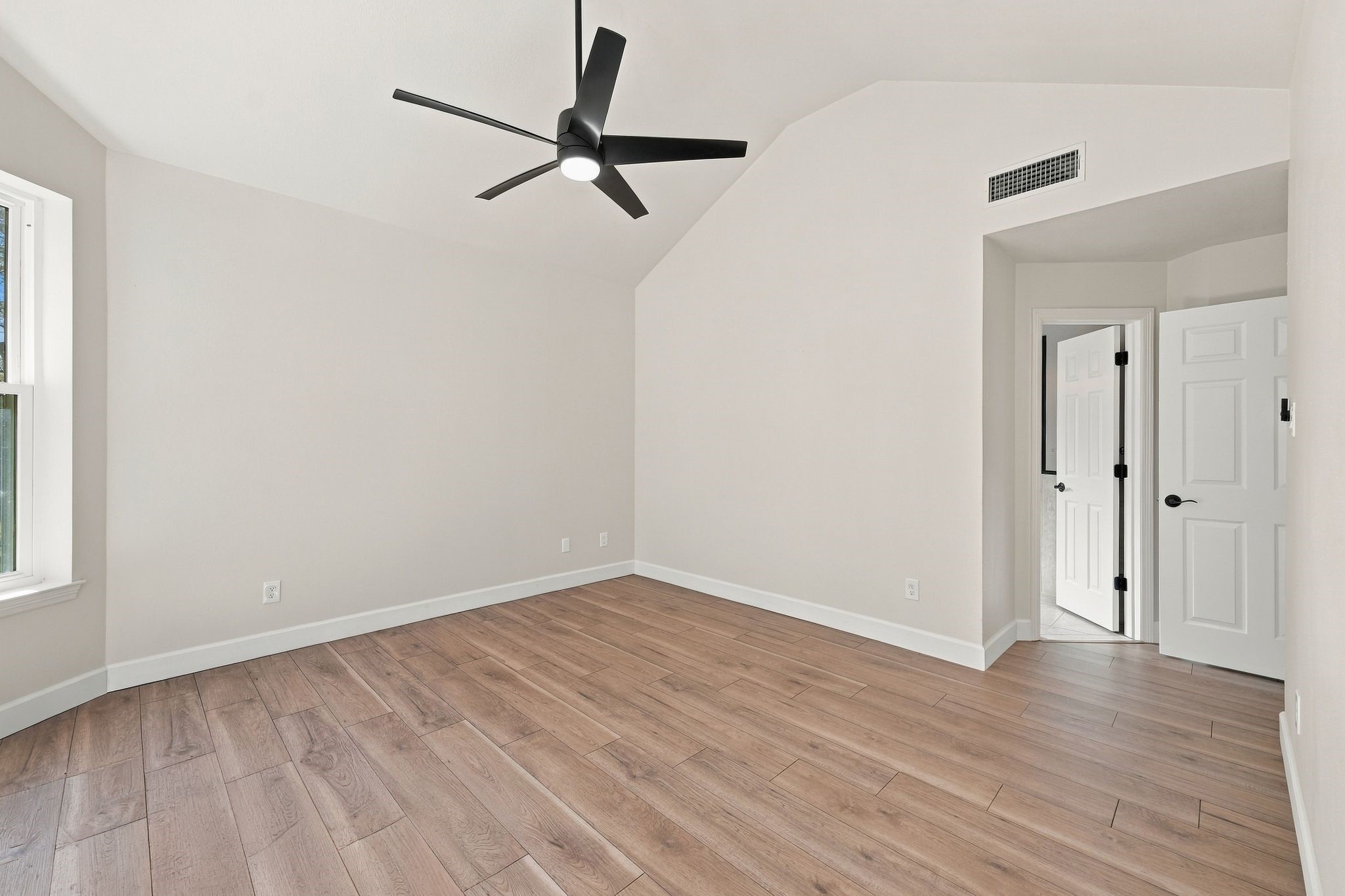 View of primary bedroom showing the doors to the hallway and to the ensuite bath.