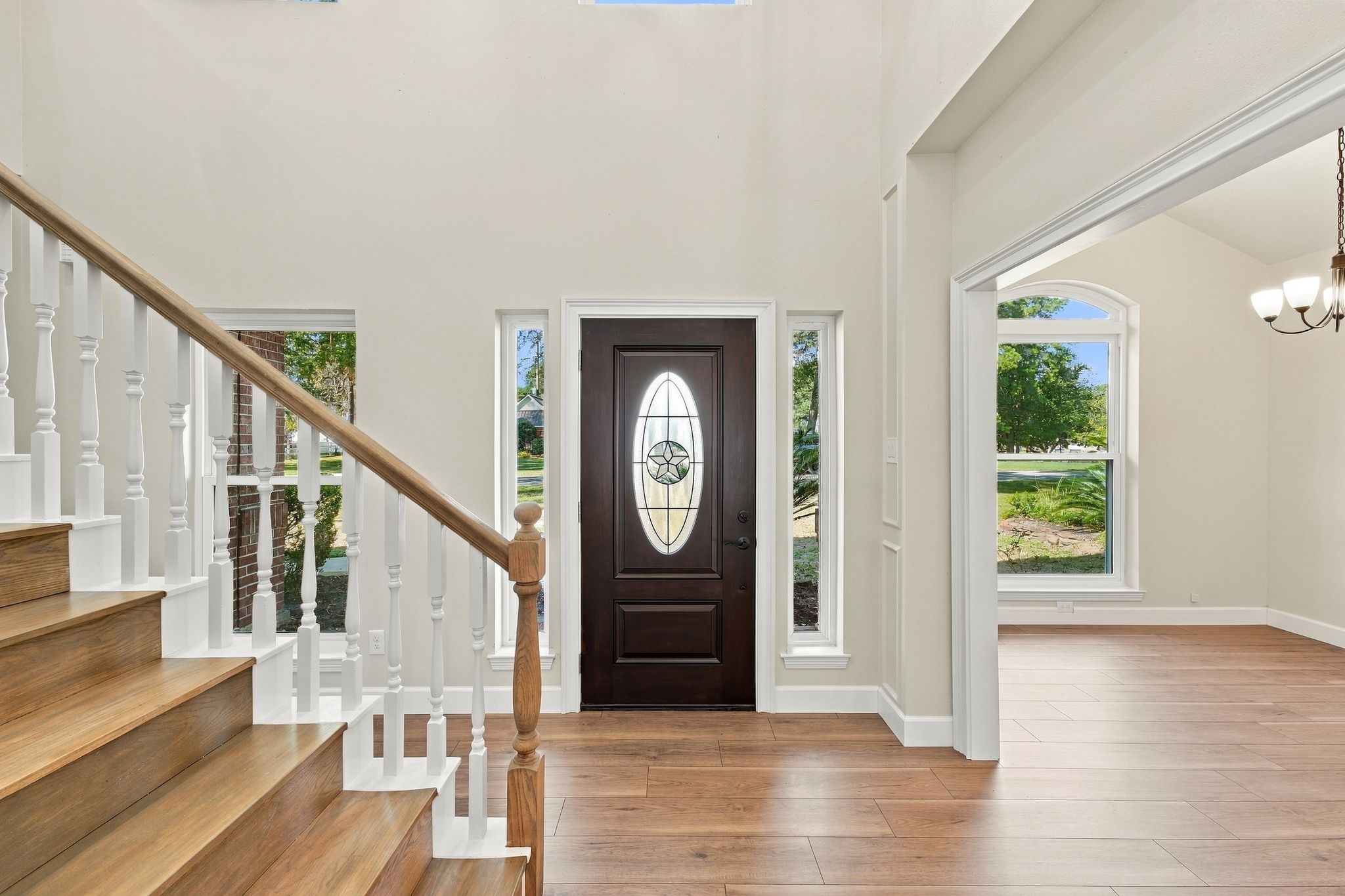 The entry way leads to a home office (to the right in this picture) and to the staircase. Notice the gorgeous Laminate wood look floors and fresh neutral paint!