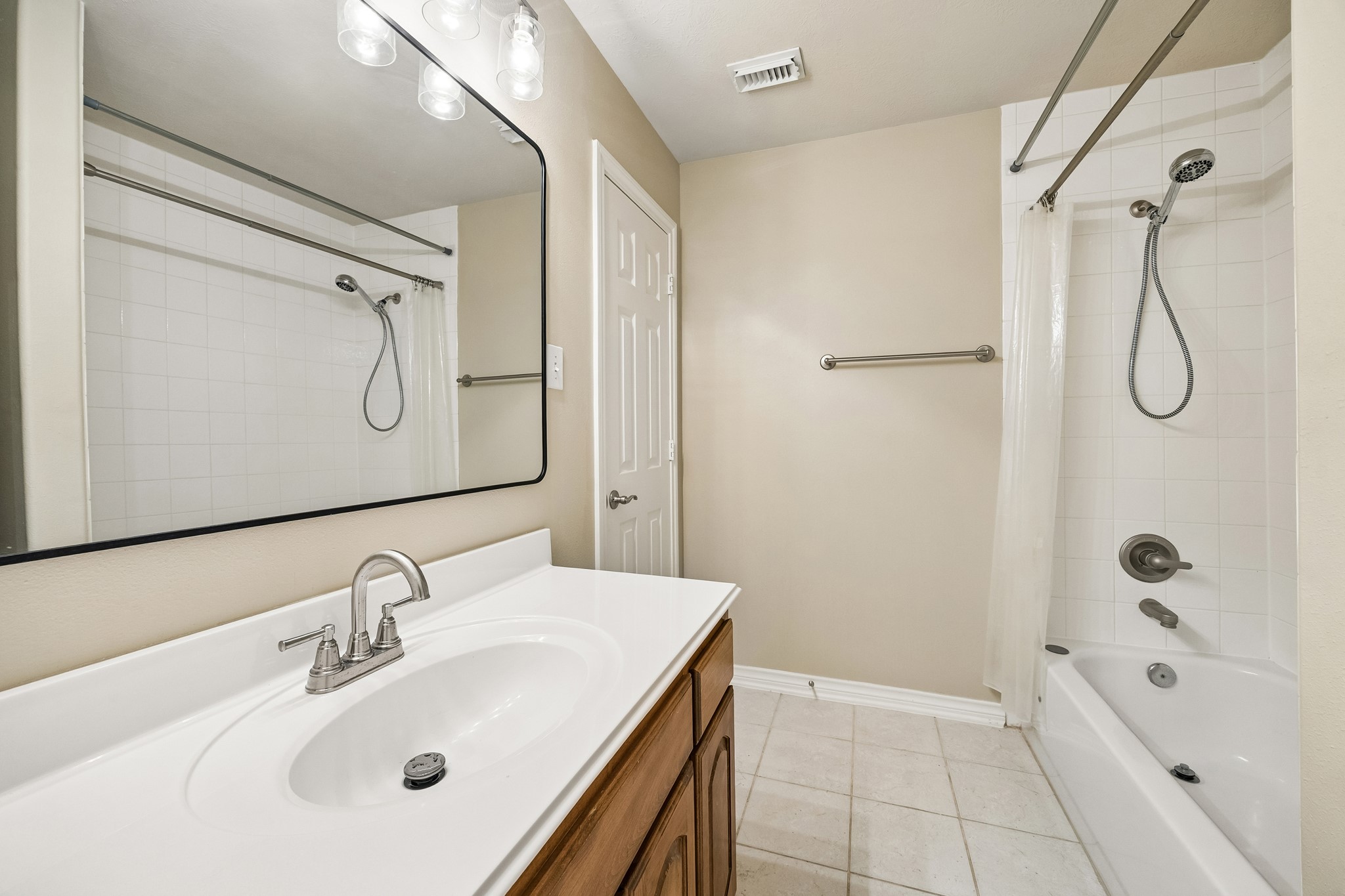 Bright secondary bath features a spacious vanity with ample counter space, updated fixtures, a tub/shower combination, and a clean neutral palette, offering a fresh and functional space for family or guests.